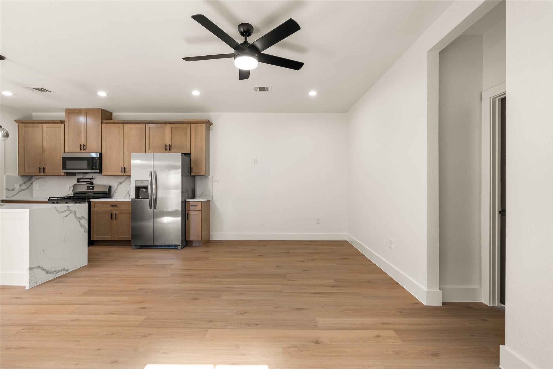 5321 Rue Street, Houston, TX 77033 Expansive open-concept layout bright neutral tones, matte black ceiling fan, and plenty of space for customizable furniture arrangements.