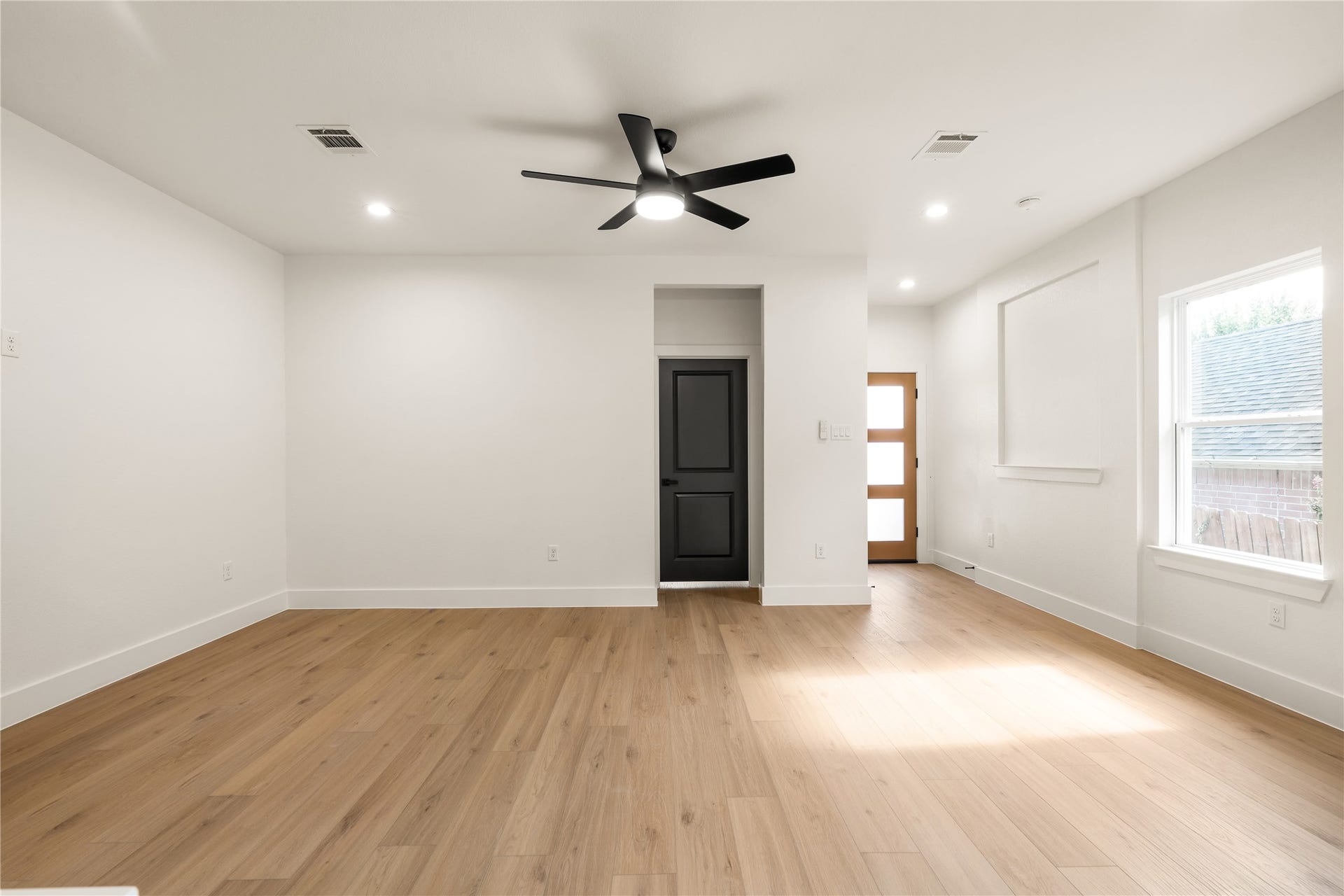 5321 Rue Street, Houston, TX 77033 Light and airy main level recessed lighting throughout, private entryway view, and natural light pouring in from the side window.
