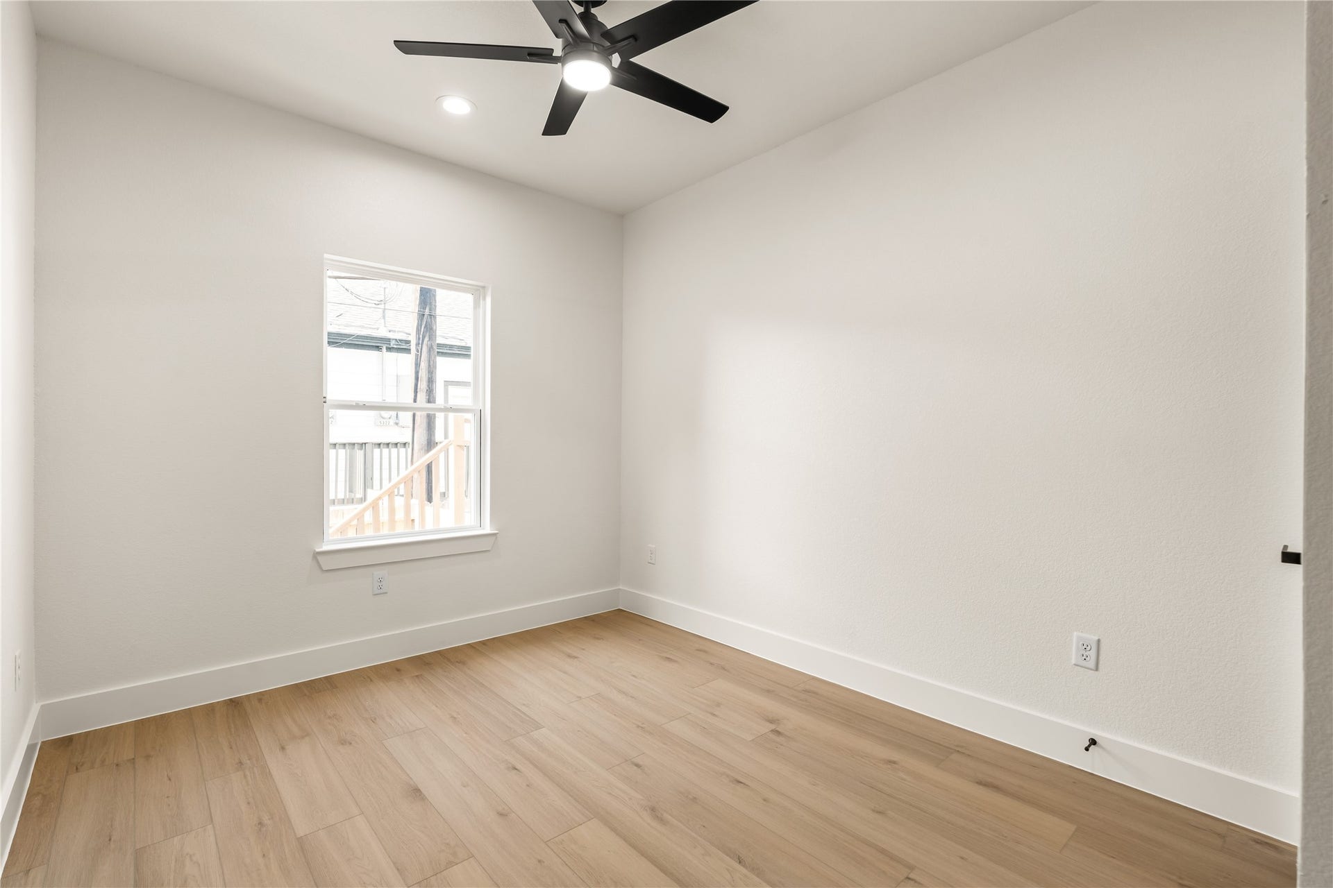 5321 Rue Street, Houston, TX 77033 Quiet corner bedroom streams of natural light, matte black ceiling fan, and crisp modern trim package.