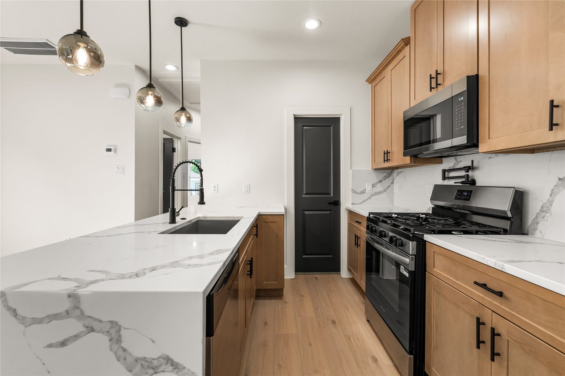 5321 Rue Street, Houston, TX 77033 Thoughtfully crafted kitchen workspace sleek gooseneck faucet, pot filler detail, quartz waterfall counter, and adjacent walk-in pantry.