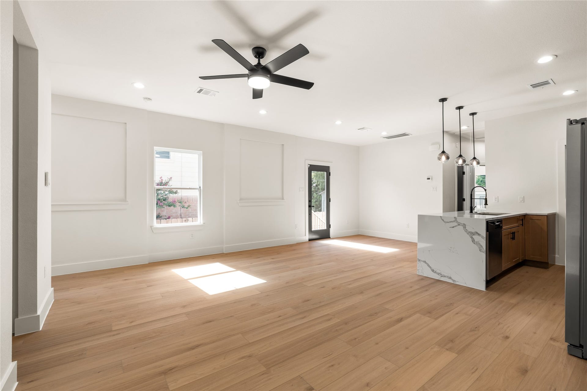 5321 Rue Street, Houston, TX 77033 Chef's kitchen overlooking the living zone waterfall edge quartz island, pendant drop lighting, and direct access to the back patio.