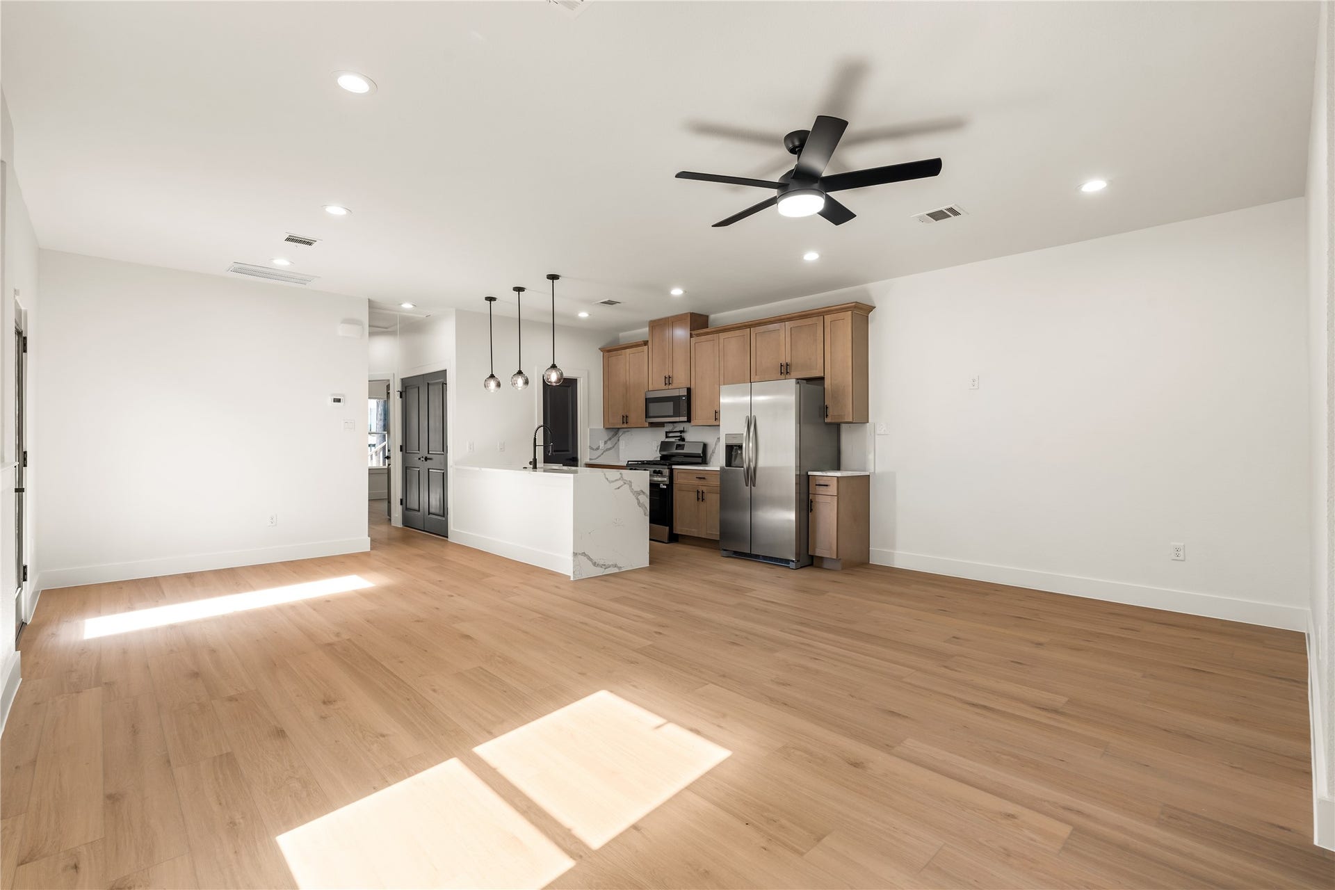 5321 Rue Street, Houston, TX 77033 Sun-drenched main living space seamless flow between the living area and kitchen, anchored by a sleek waterfall island and designer lighting.