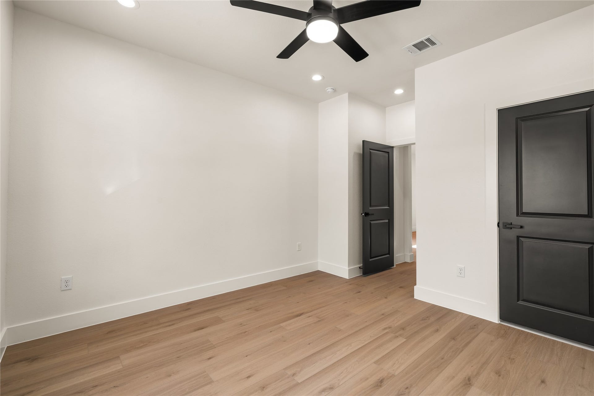 5321 Rue Street, Houston, TX 77033 Versatile second bedroom crisp modern contrast with matte black doors, ceiling fan light kit, and generous wall space.