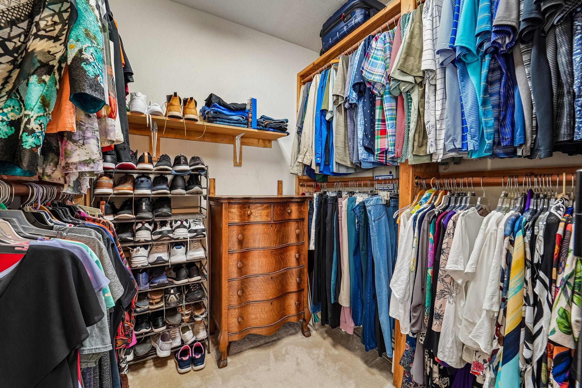 14 Serene Creek Place, The Woodlands, TX 77382 Spacious walk-in closet featuring ample hanging space, a shoe organizer, and is big enough to fit a wooden dresser for additional storage.