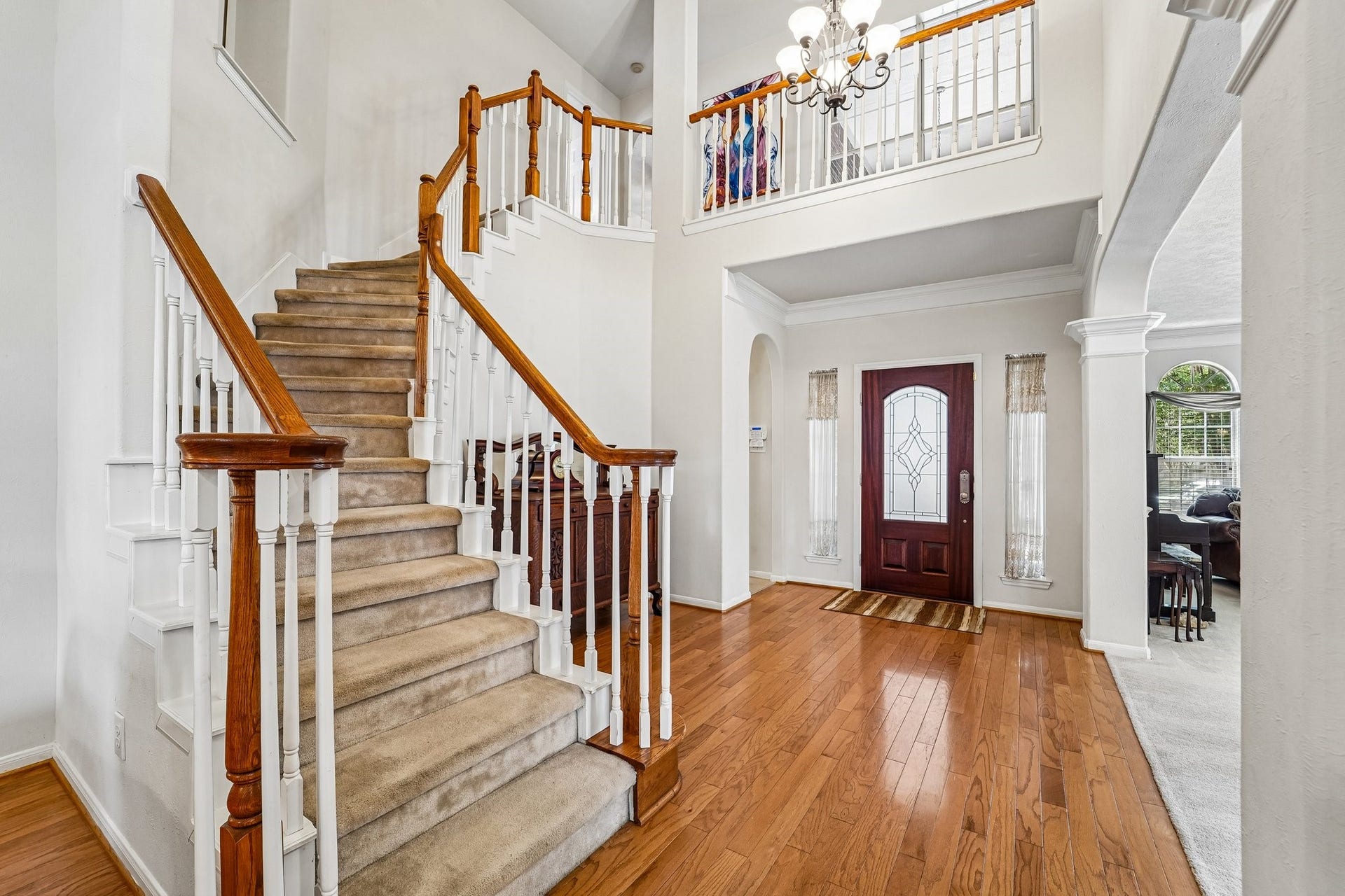 14 Serene Creek Place, The Woodlands, TX 77382 Elegant entryway with a grand staircase, hardwood floors, and tall ceiling, creating a welcoming and sophisticated first impression.