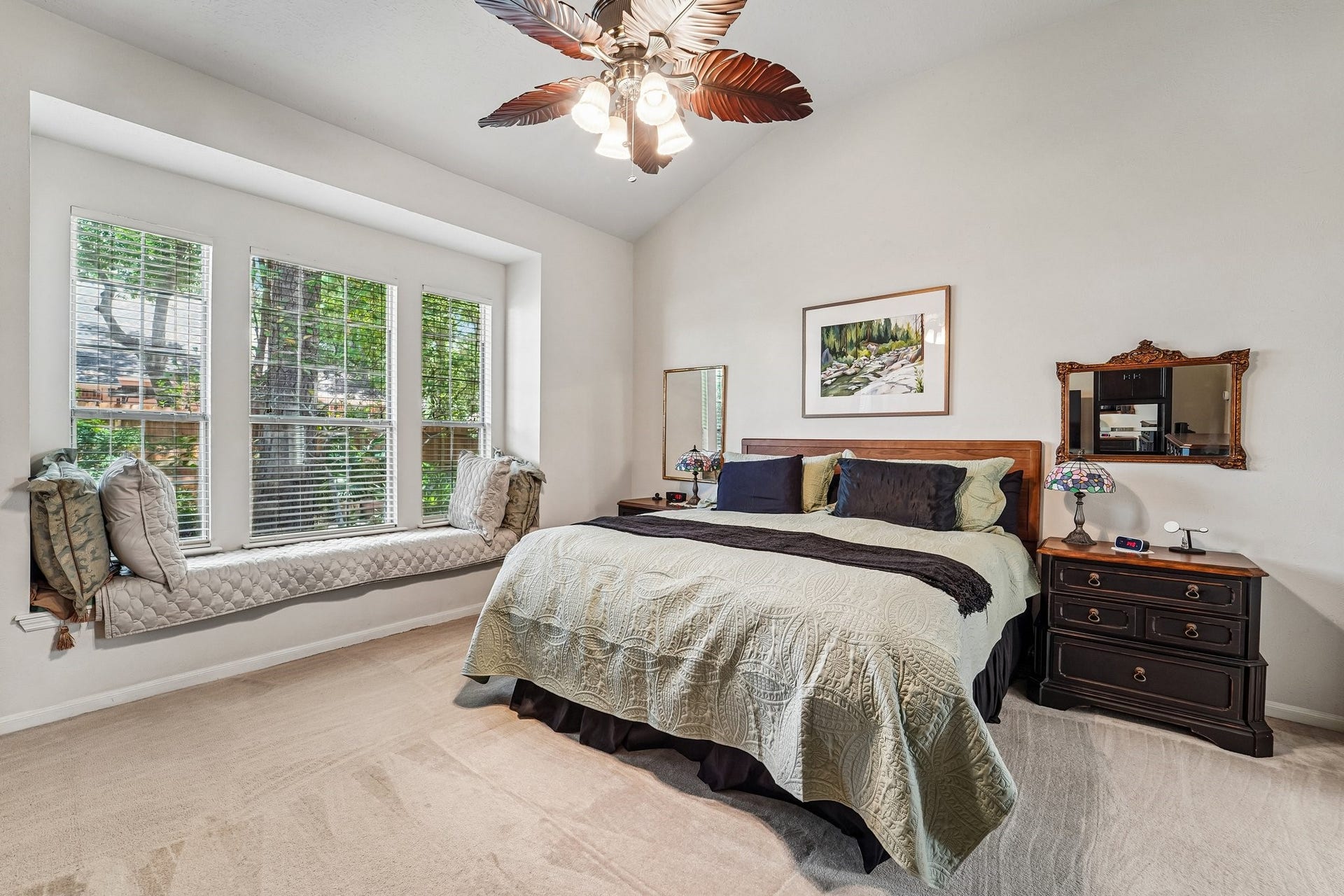14 Serene Creek Place, The Woodlands, TX 77382 Inviting bedroom with abundant natural light features a cozy window seat and warm, elegant decor.