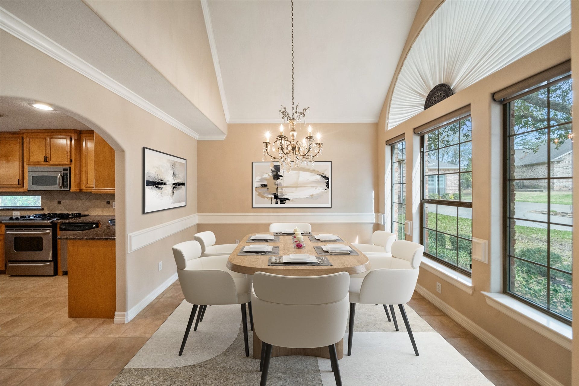 901 Longmire Road, #28, Conroe, TX 77304 This inviting virtually staged dining area features large windows for ample natural light, a stylish chandelier, and elegant trim. It seamlessly connects to a modern kitchen creating a perfect setting for entertaining and family gatherings.