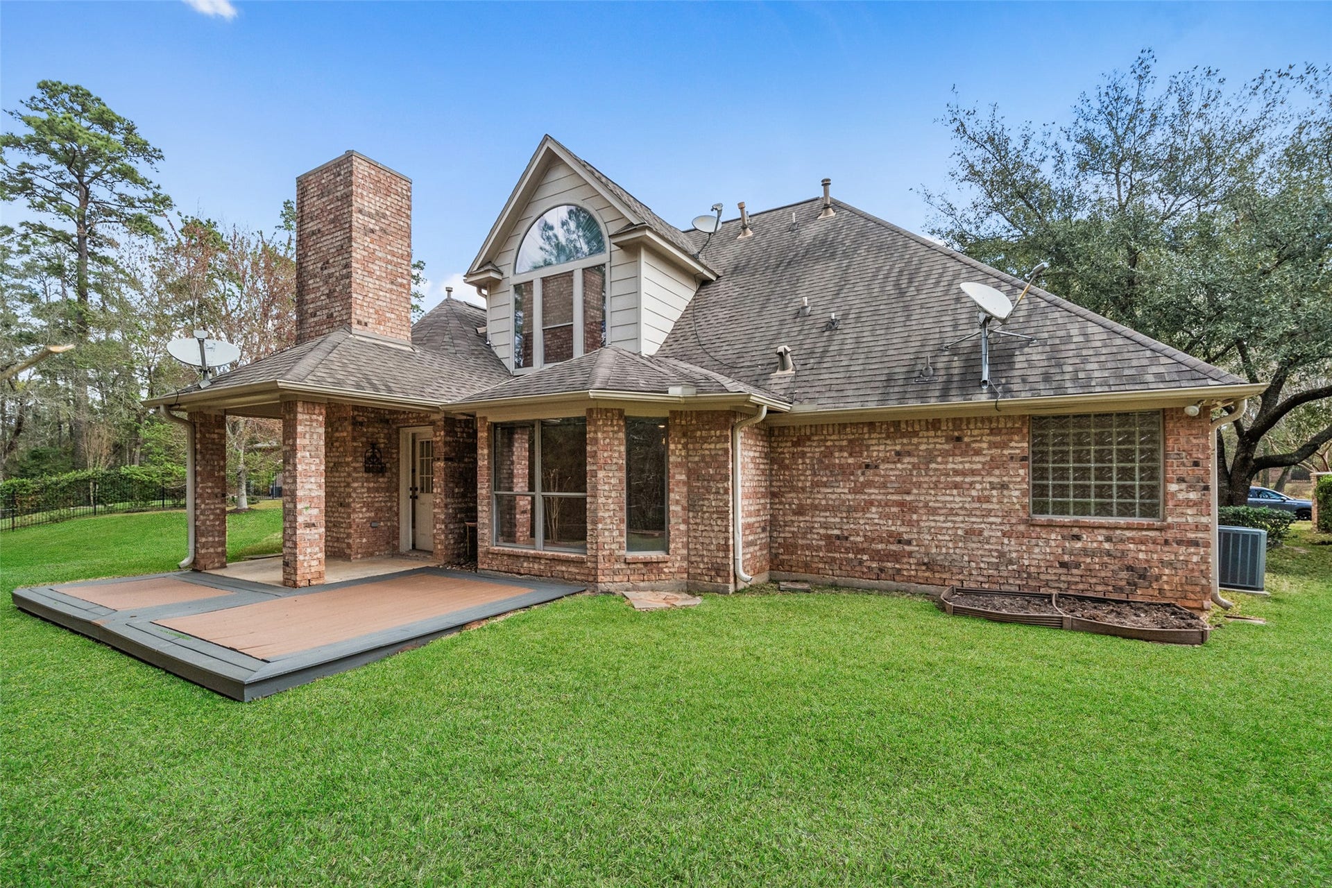 901 Longmire Road, #28, Conroe, TX 77304 Spacious backyard and a large deck, perfect for outdoor entertaining. Surrounded by lush greenery for added privacy.