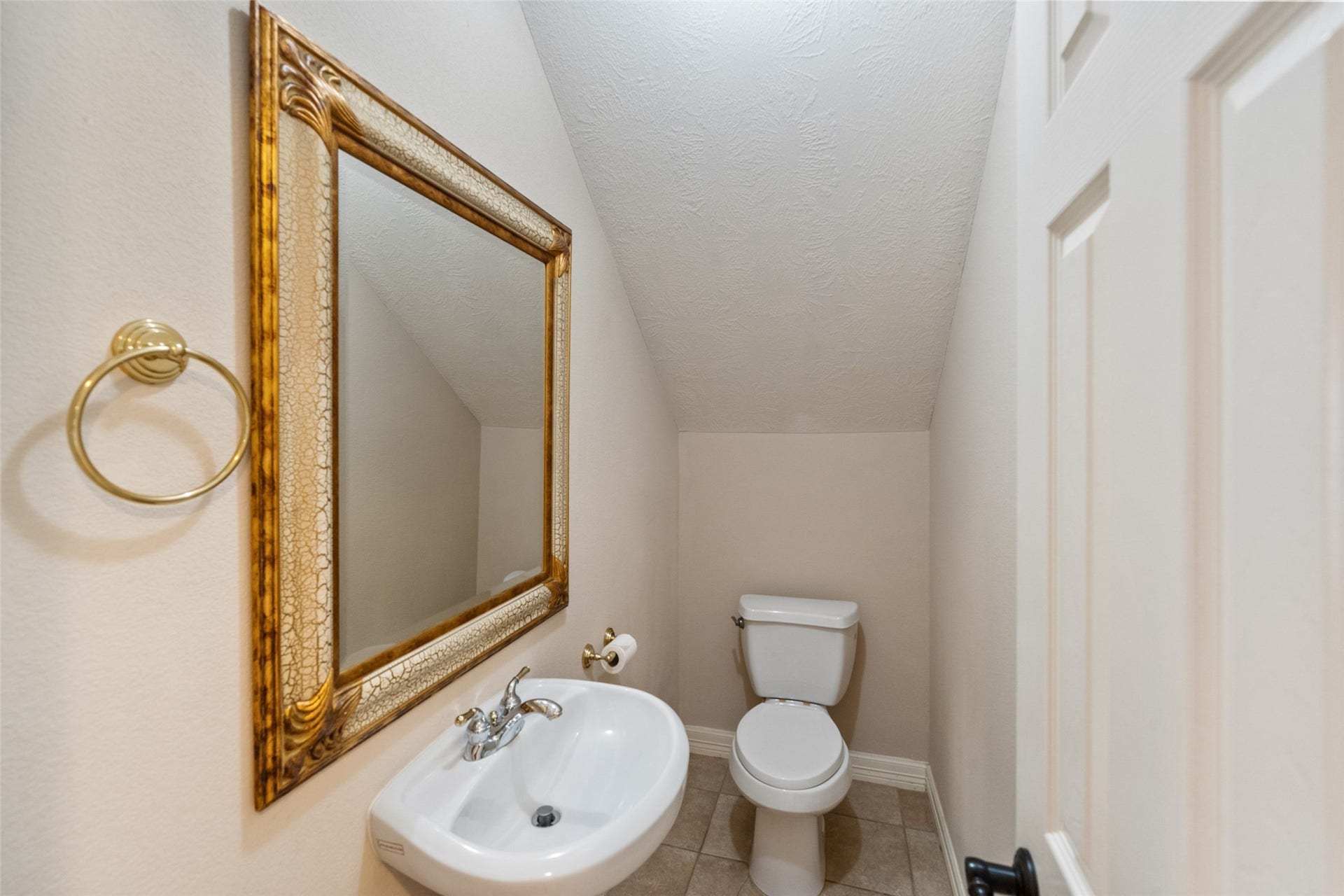 901 Longmire Road, #28, Conroe, TX 77304 This is a compact half-bathroom with a pedestal sink and a large decorative mirror on the wall.