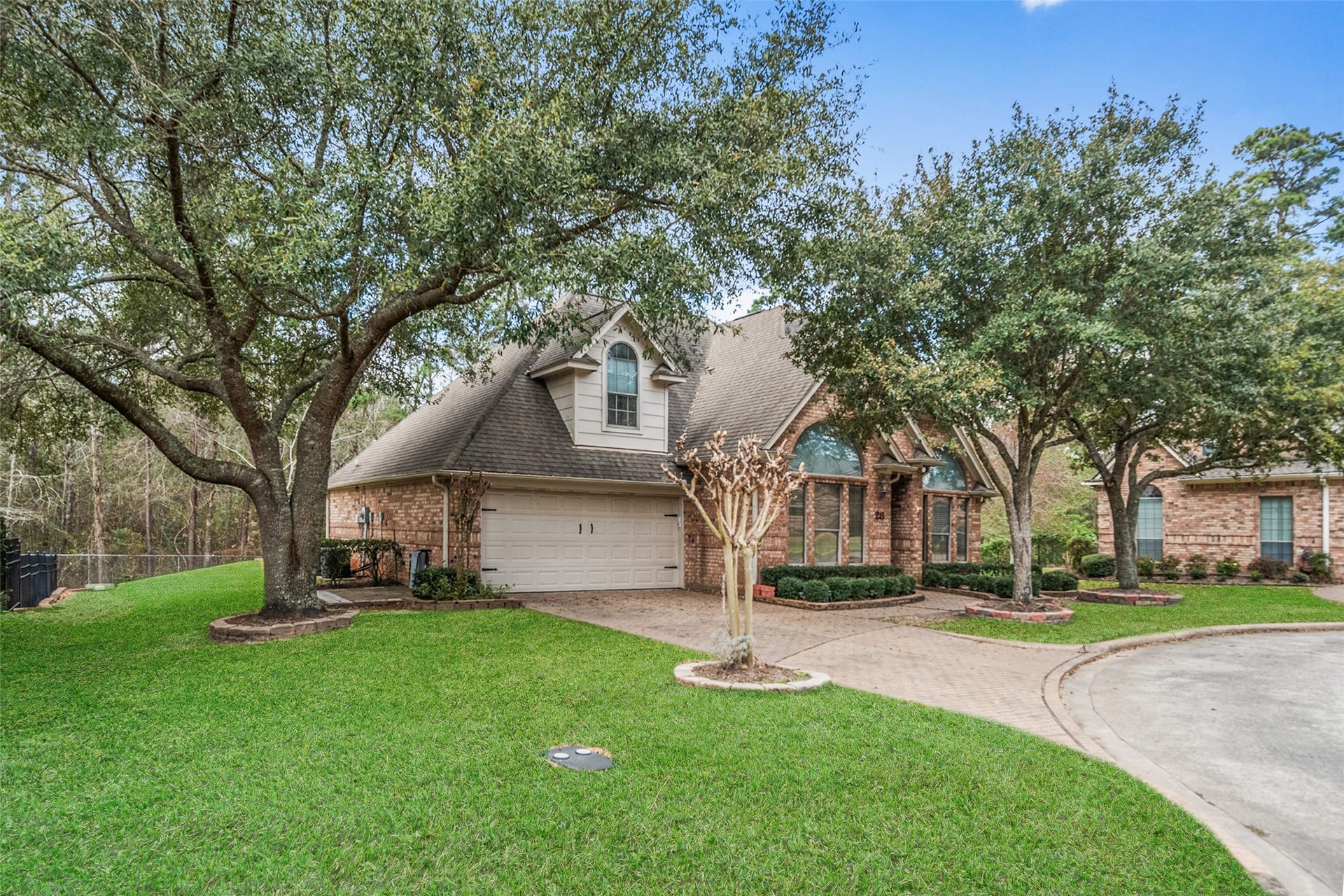 901 Longmire Road, #28, Conroe, TX 77304 Charming brick home features a two-car garage and a welcoming entrance with large windows. Located in a serene neighborhood, perfect for family living.