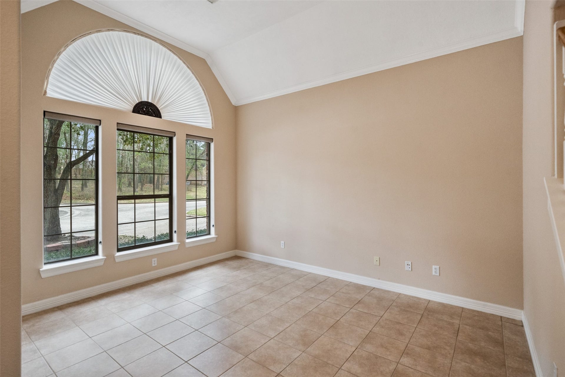 901 Longmire Road, #28, Conroe, TX 77304 This formal living/home office features large windows with a semi-circular design, allowing ample natural light. It has neutral walls and tiled flooring, creating a bright and open atmosphere.