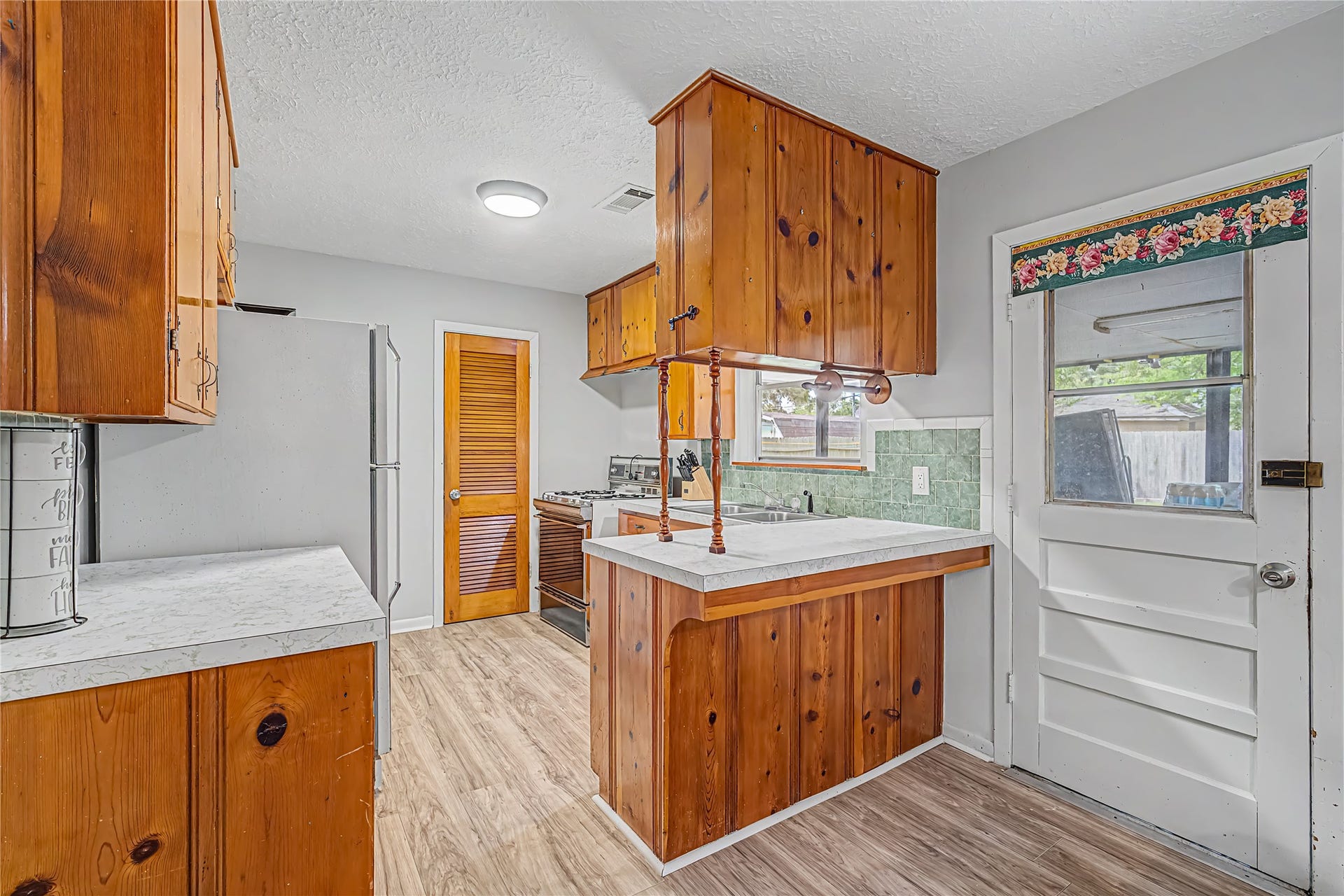 Charming kitchen with warm wood cabinetry, a cozy breakfast bar, and modern appliances.
