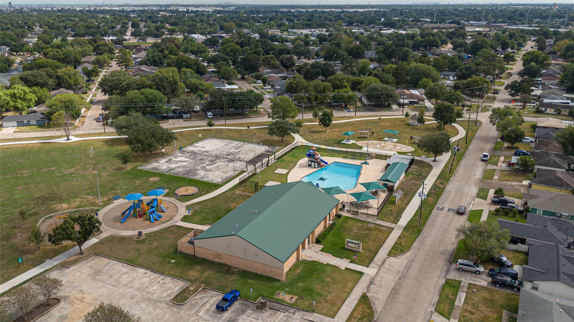 Explore a vibrant community hub featuring a spacious recreational area with a playground, a swimming pool, and ample green space, set in a family-friendly neighborhood.