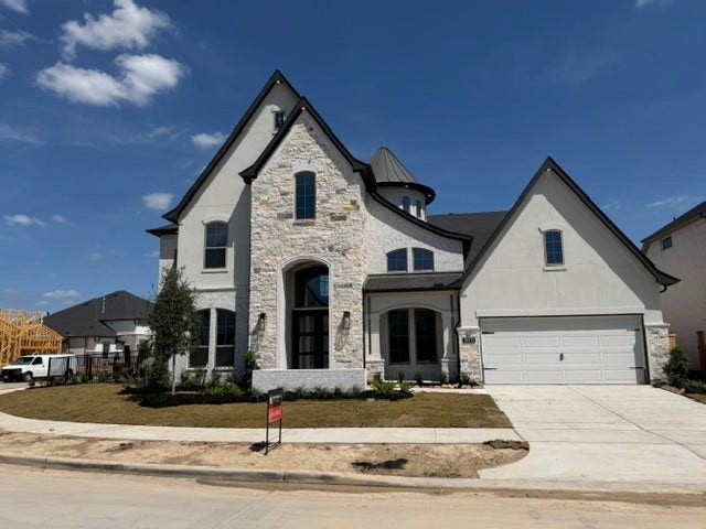 10514 Sedge Blade Lane, Cypress, TX 77433 This home is a show-stopper from the street wth its high-pitched roof line and round turret peeking out from above.