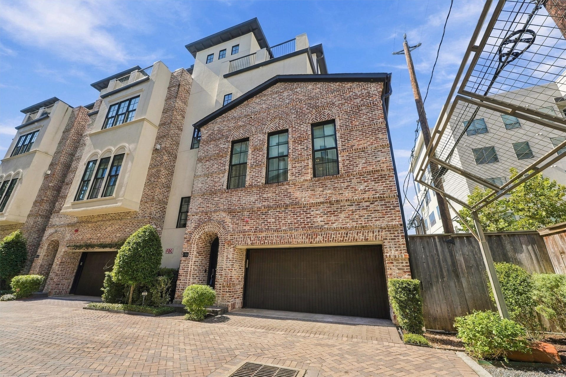 1306 Castle Court, Houston, TX 77006 Brick-and-stucco faade with herringbone-set arches and black-framed windows, inside the gates of Castle Court Terrace