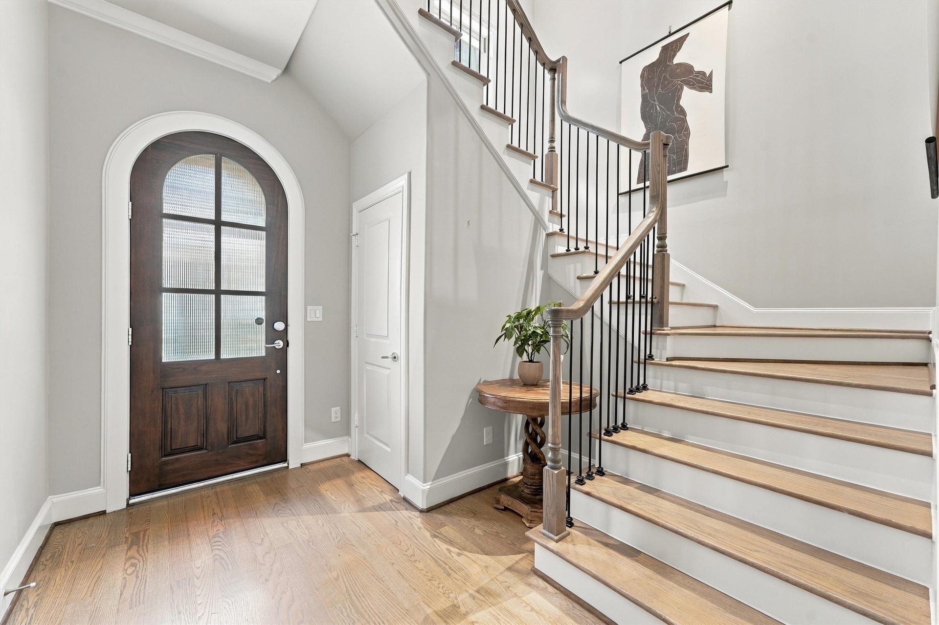 1306 Castle Court, Houston, TX 77006 Foyer with a sculptural staircase of hardwood treads and wrought-iron spindles