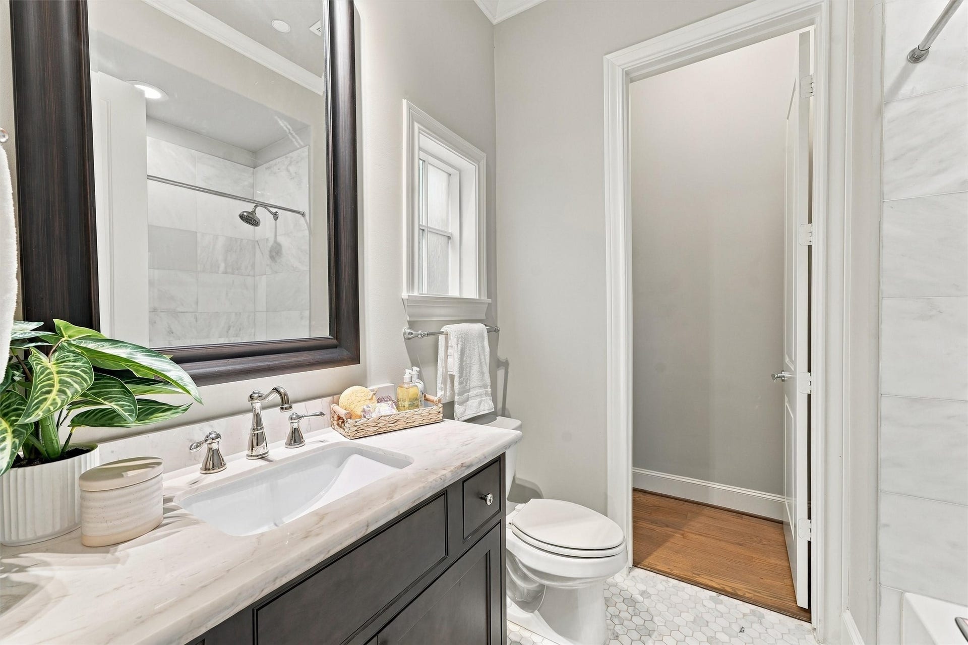 1306 Castle Court, Houston, TX 77006 Guest bath with white marble, a hexagonal mosaic floor and polished-nickel fixtures