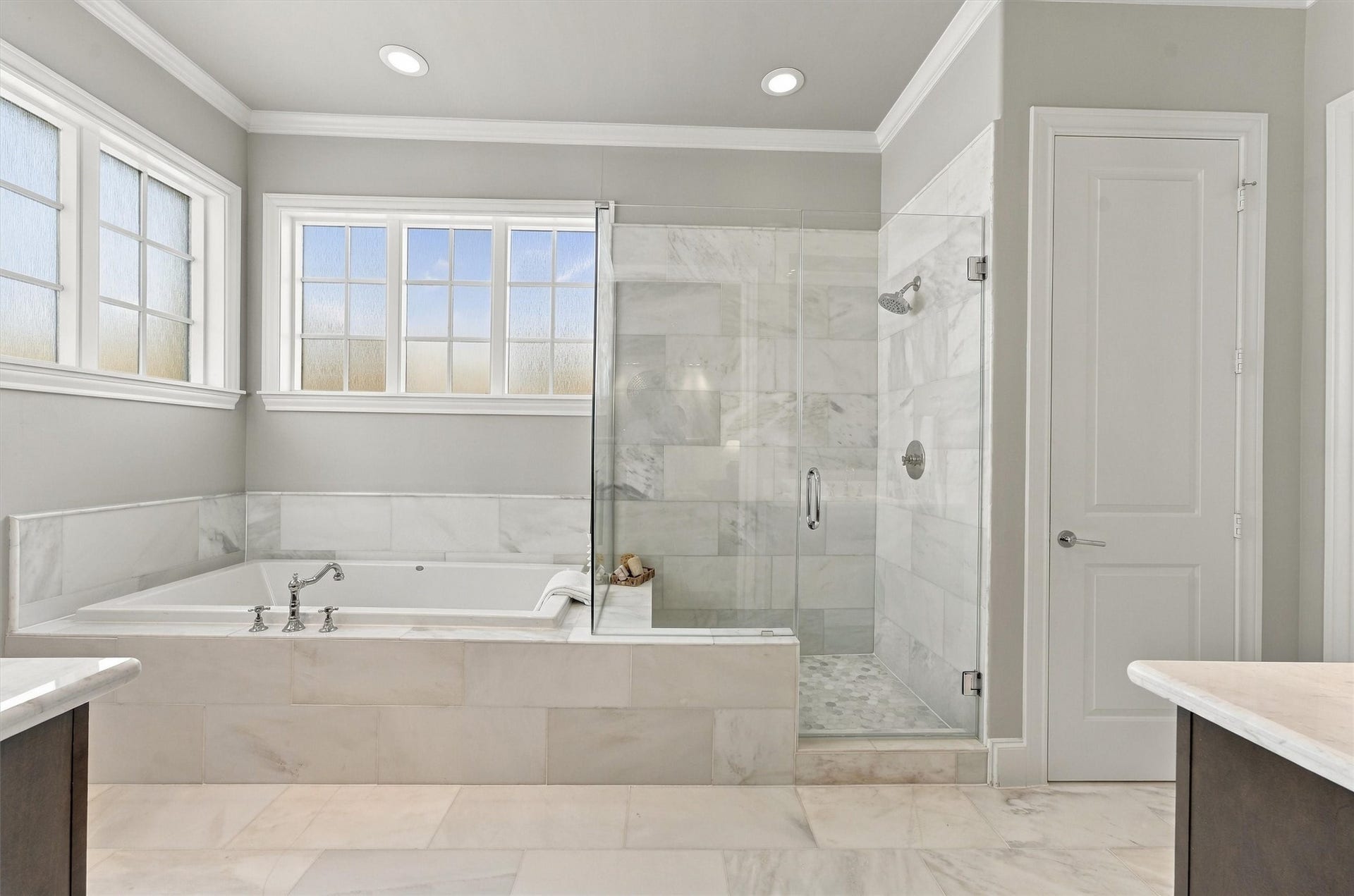 1306 Castle Court, Houston, TX 77006 Primary bath with a marble-wrapped soaking tub and frameless glass shower