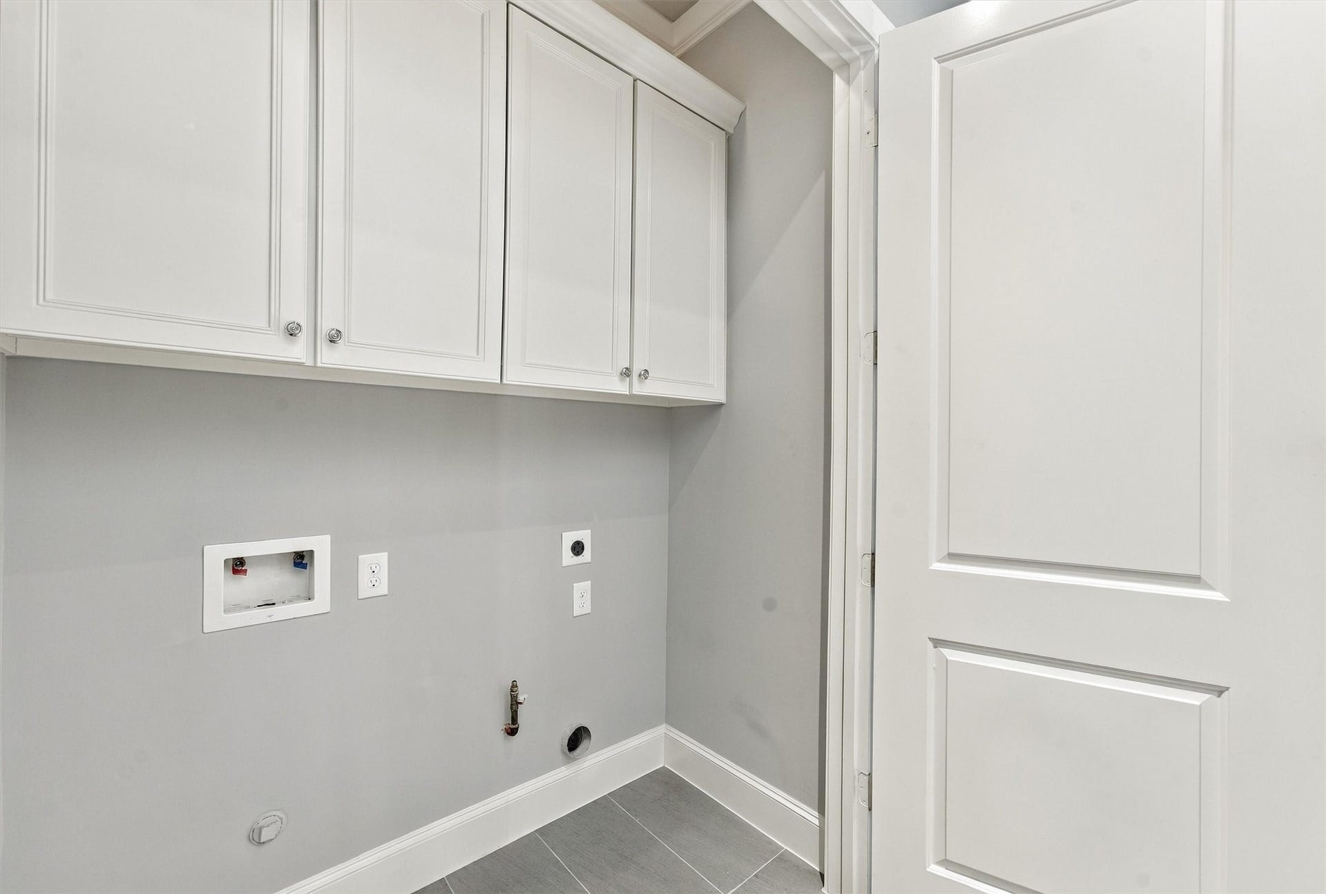 1306 Castle Court, Houston, TX 77006 Utility room with full-size laundry connections and cabinetry above