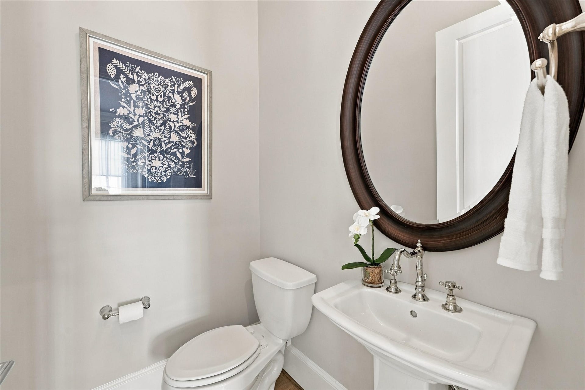 1306 Castle Court, Houston, TX 77006 Powder room with a pedestal sink, cross-handle faucet and oval mirror