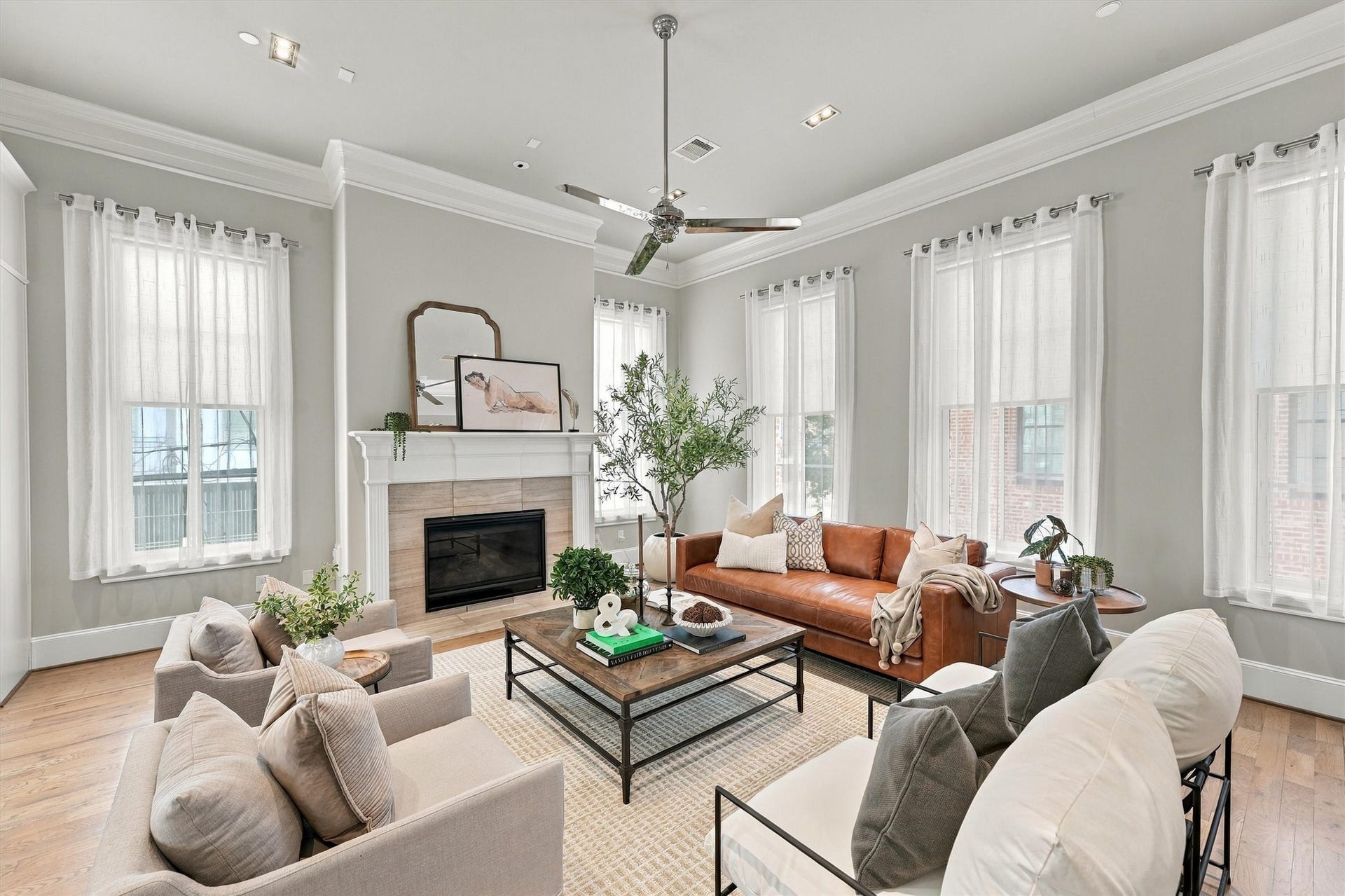 1306 Castle Court, Houston, TX 77006 Great room with tall windows on two walls and a gas-log fireplace