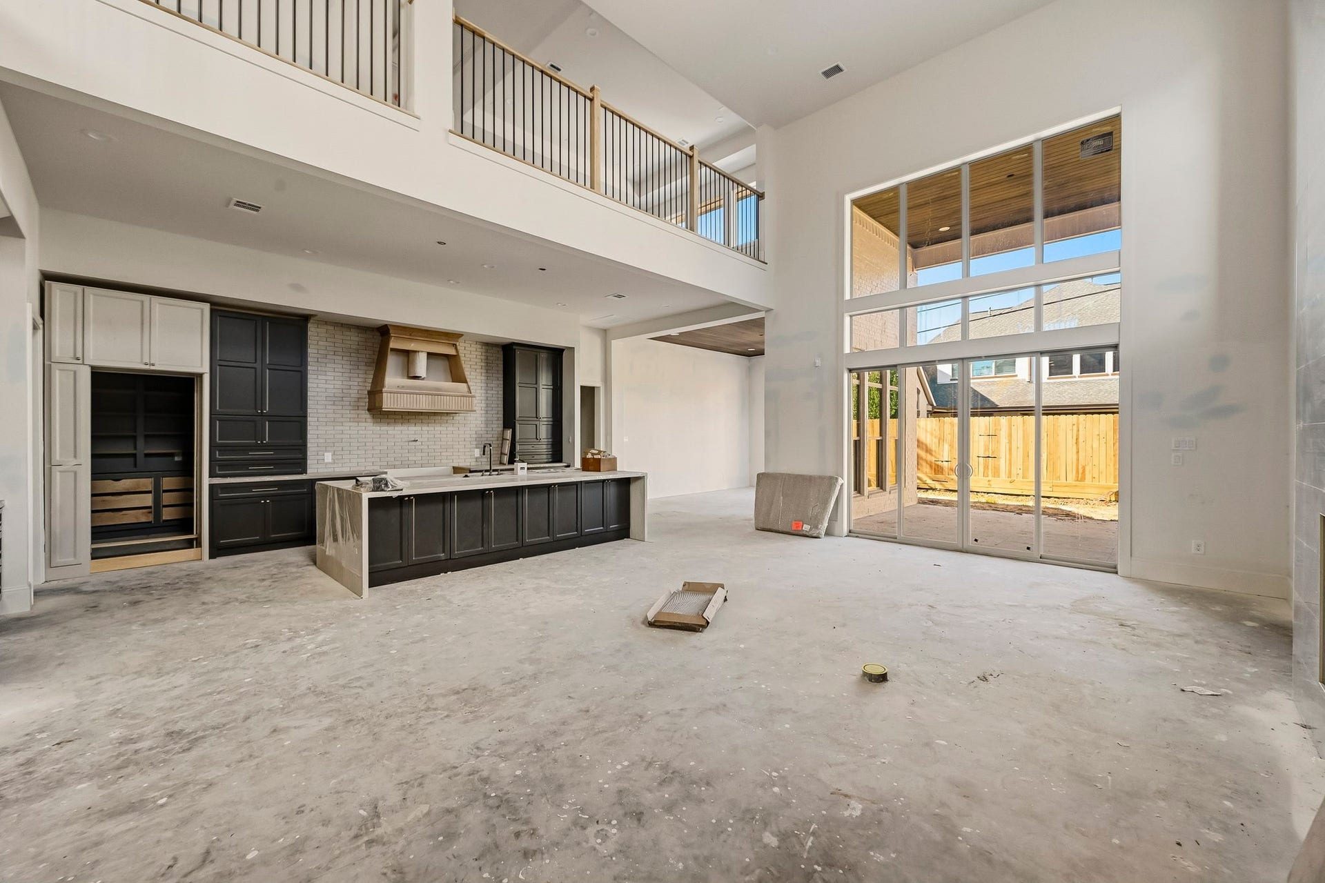 6618 Sivley Street, Hockley, TX 77055 Stunning open-concept living area with soaring ceilings, expansive windows, and a sleek modern kitchen complete with chic cabinetry and a large island!