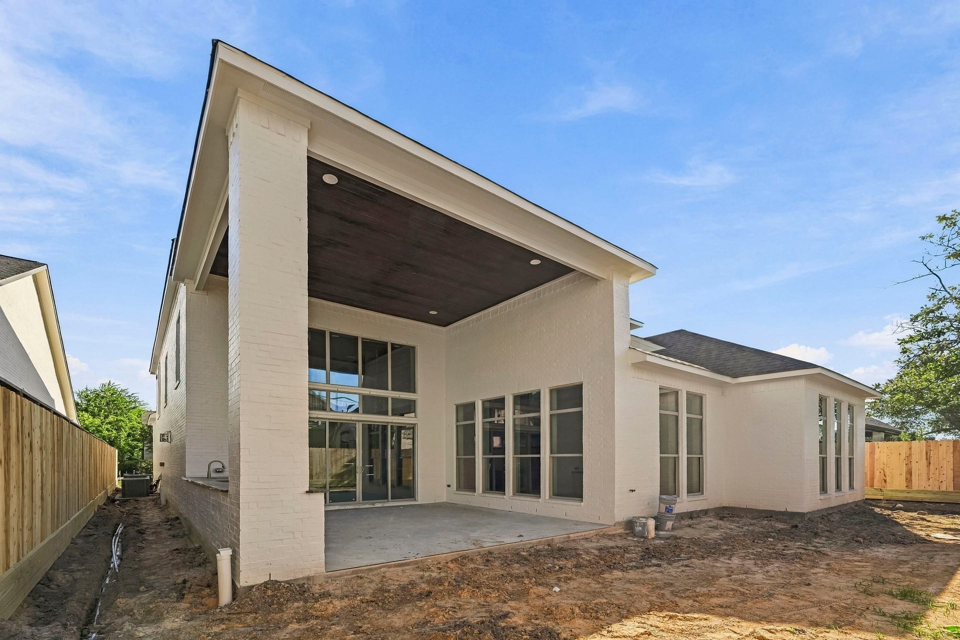 6618 Sivley Street, Hockley, TX 77055 Modern home with a covered patio, large windows, and a fenced yard, perfect for outdoor entertaining!