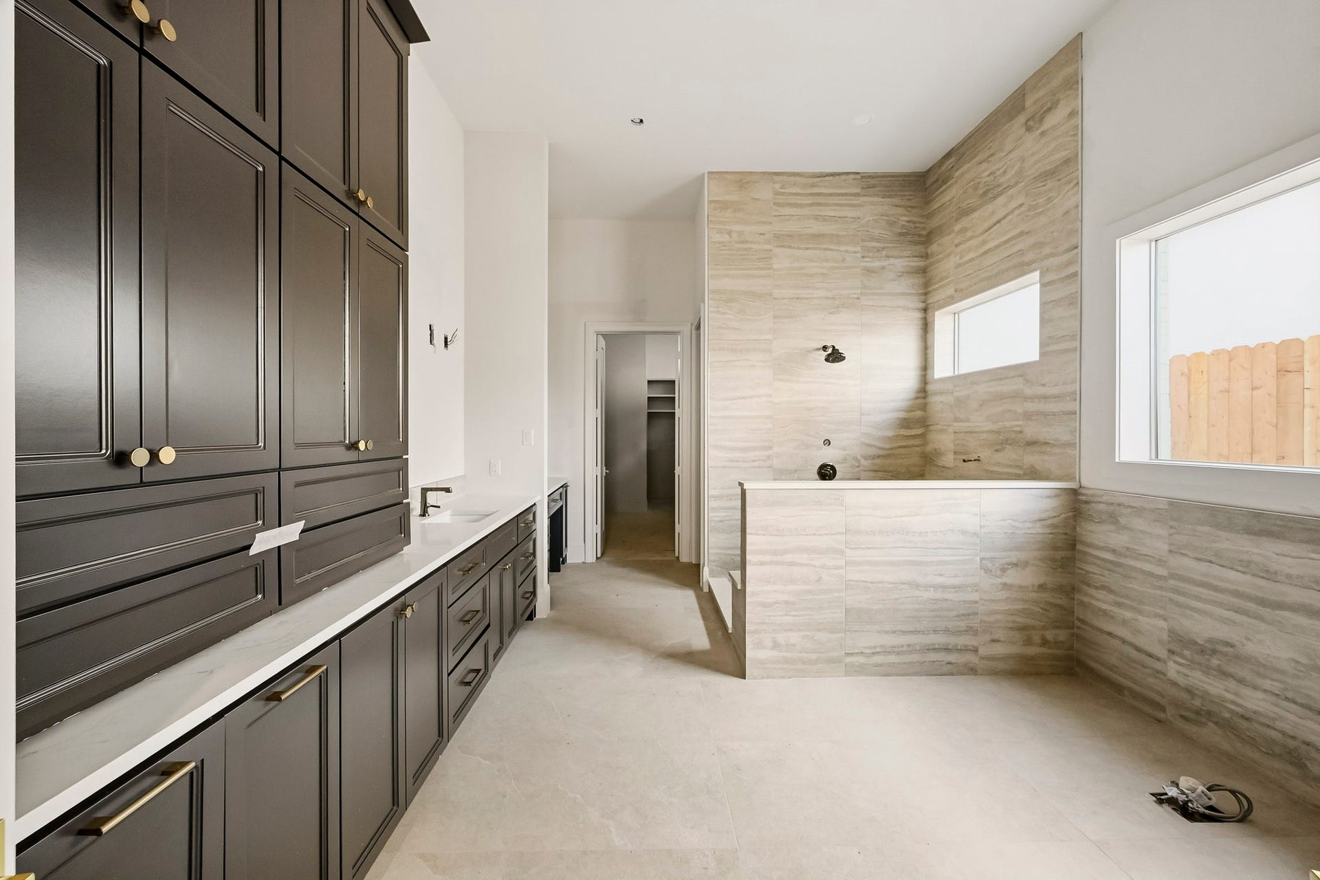 6618 Sivley Street, Hockley, TX 77055 Primary ensuite featuring elegant dark cabinetry, plenty of counter space, and a stylish tiled area with large windows for natural light!