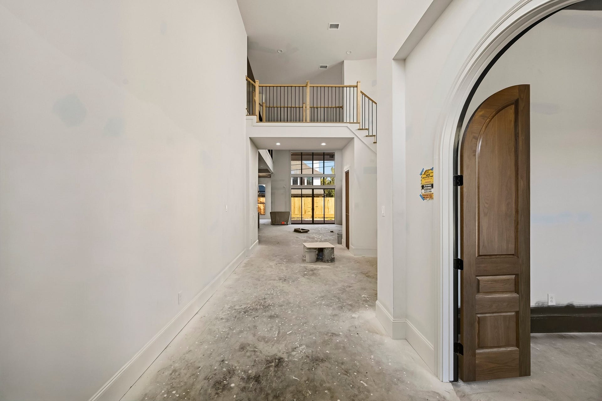 6618 Sivley Street, Hockley, TX 77055 Expansive entryway with soaring ceilings and an elegant arched doorway, leading to a bright, open living space with large windows and a view of the backyard!