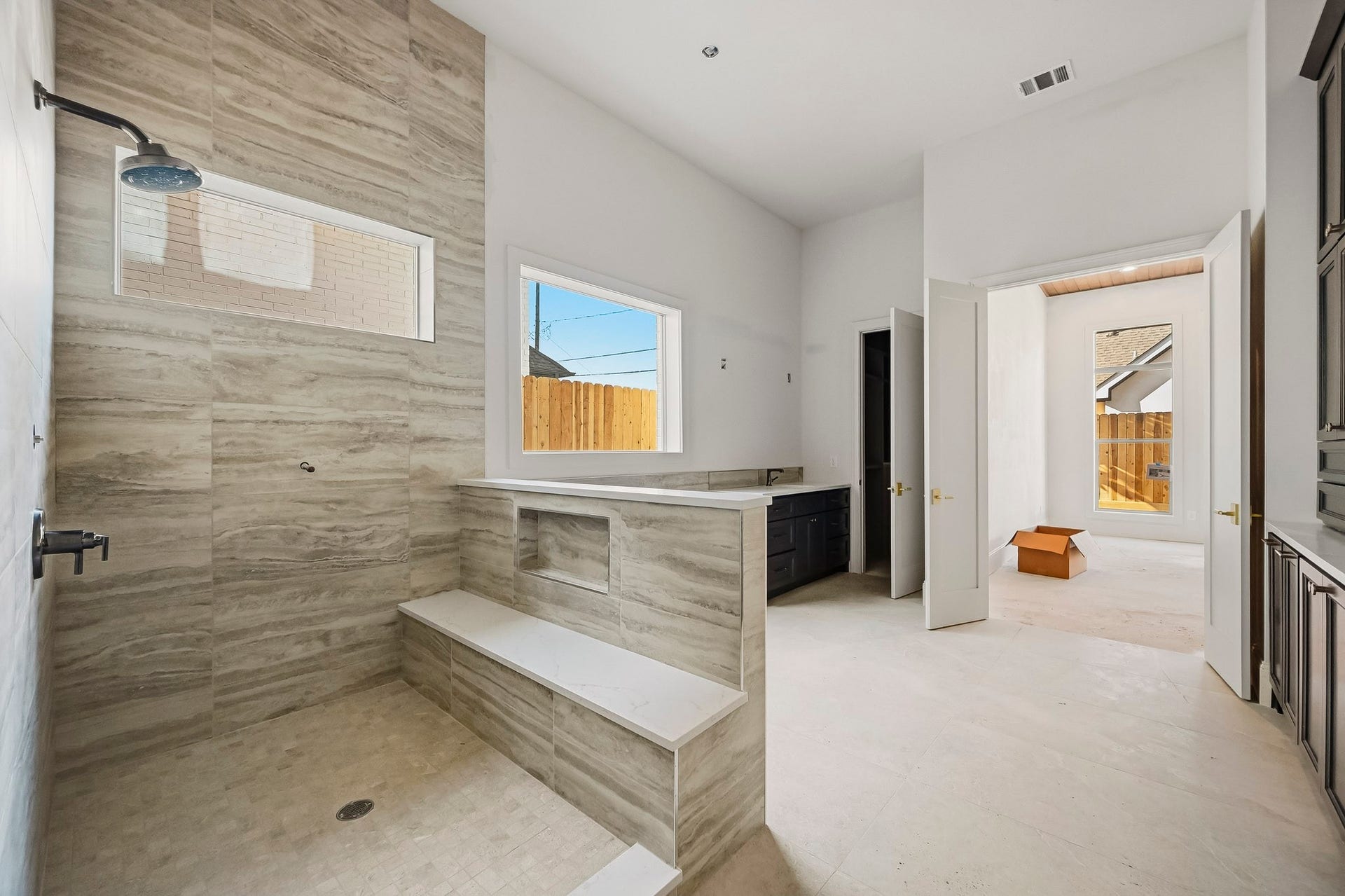 6618 Sivley Street, Hockley, TX 77055 Bright and airy bathroom featuring a large, tiled walk-in shower with a convenient built-in bench and modern fixtures, complemented by a stylish vanity area!