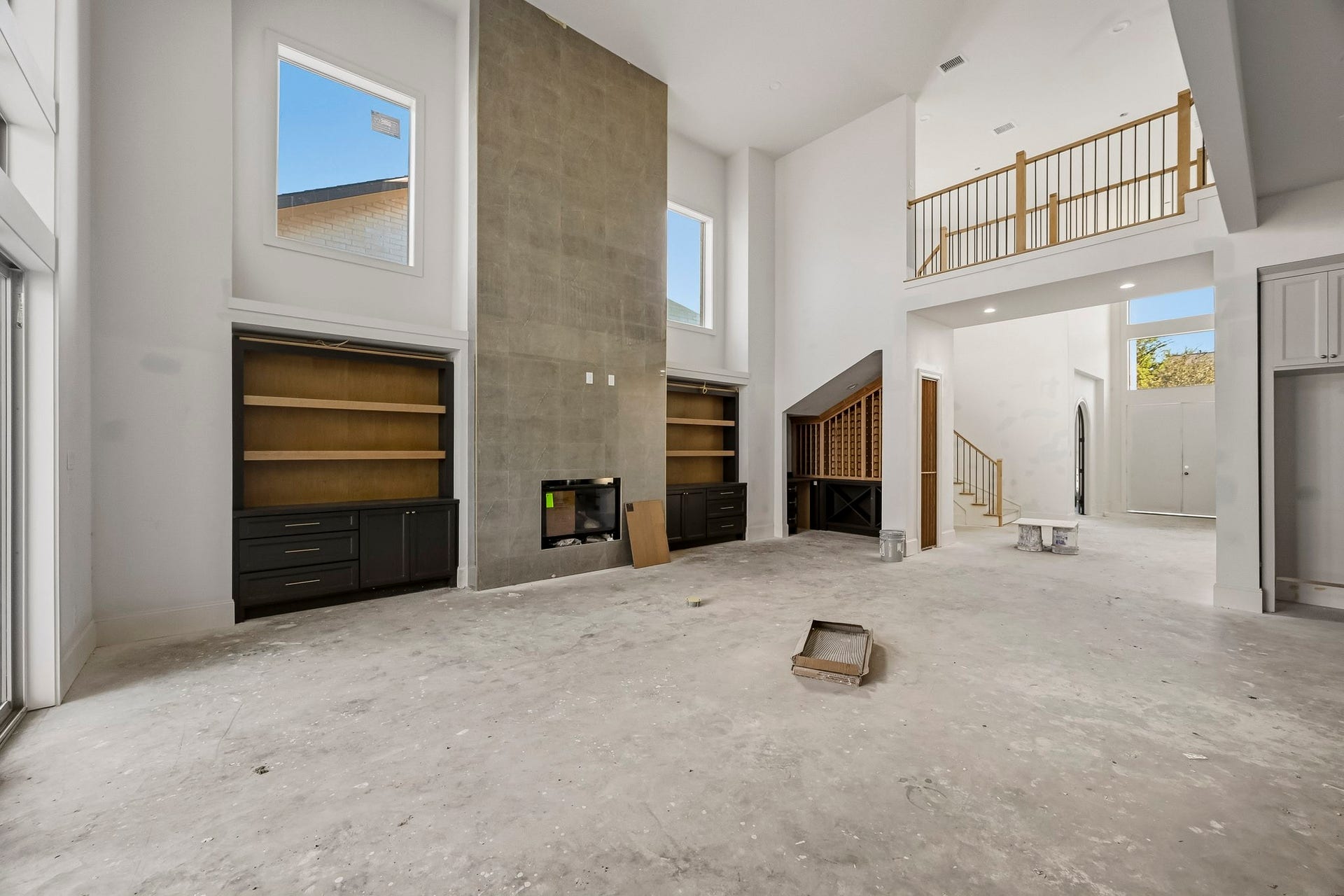 6618 Sivley Street, Hockley, TX 77055 Airy living area with high ceilings and large windows, featuring a modern fireplace and built-in shelving, offering a bright and open atmosphere!