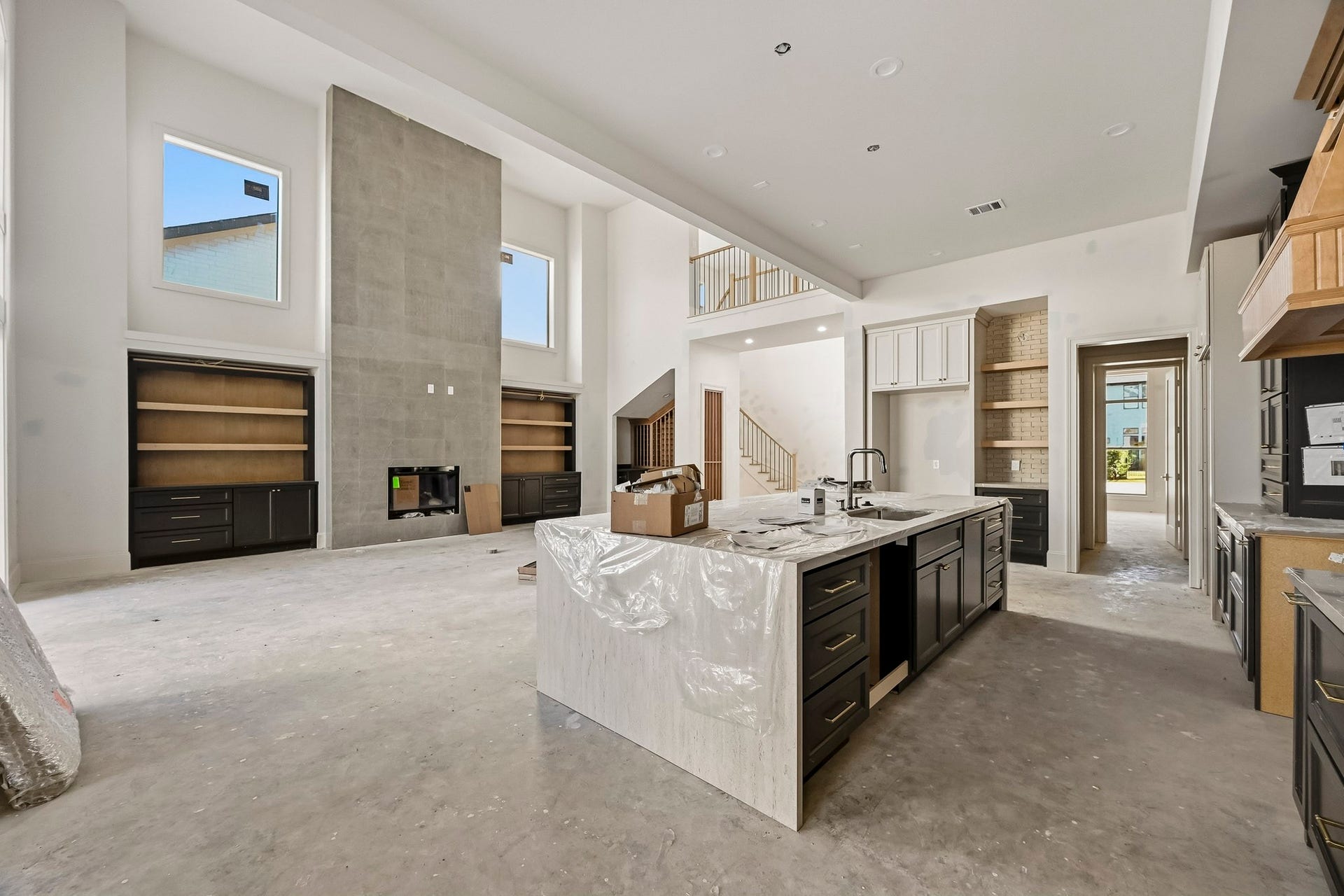 6618 Sivley Street, Hockley, TX 77055 Expansive open-concept living space with a striking double-height ceiling, modern fireplace, and a gourmet kitchen featuring a large island and sleek cabinetry!