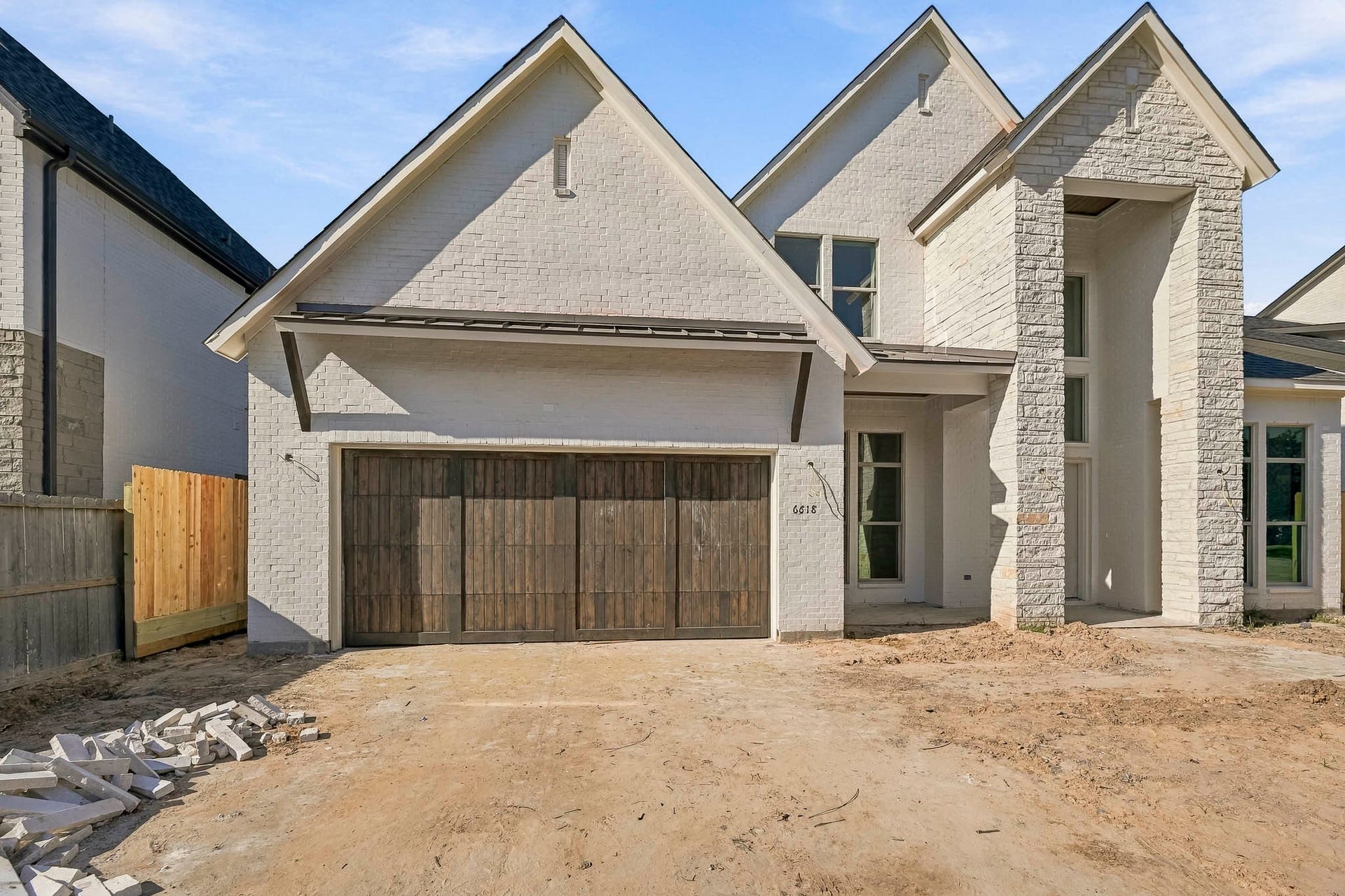 6618 Sivley Street, Hockley, TX 77055 Stunning new construction featuring a modern brick exterior with a rustic wooden garage door, offering a blend of contemporary design and timeless charm!