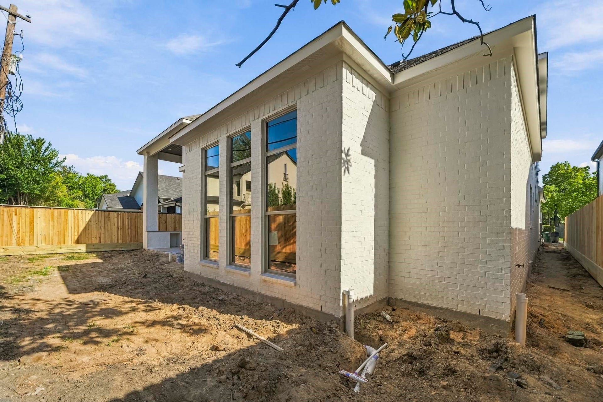 6618 Sivley Street, Hockley, TX 77055 Charming home with a sleek white brick exterior, large windows, and a spacious backyard.