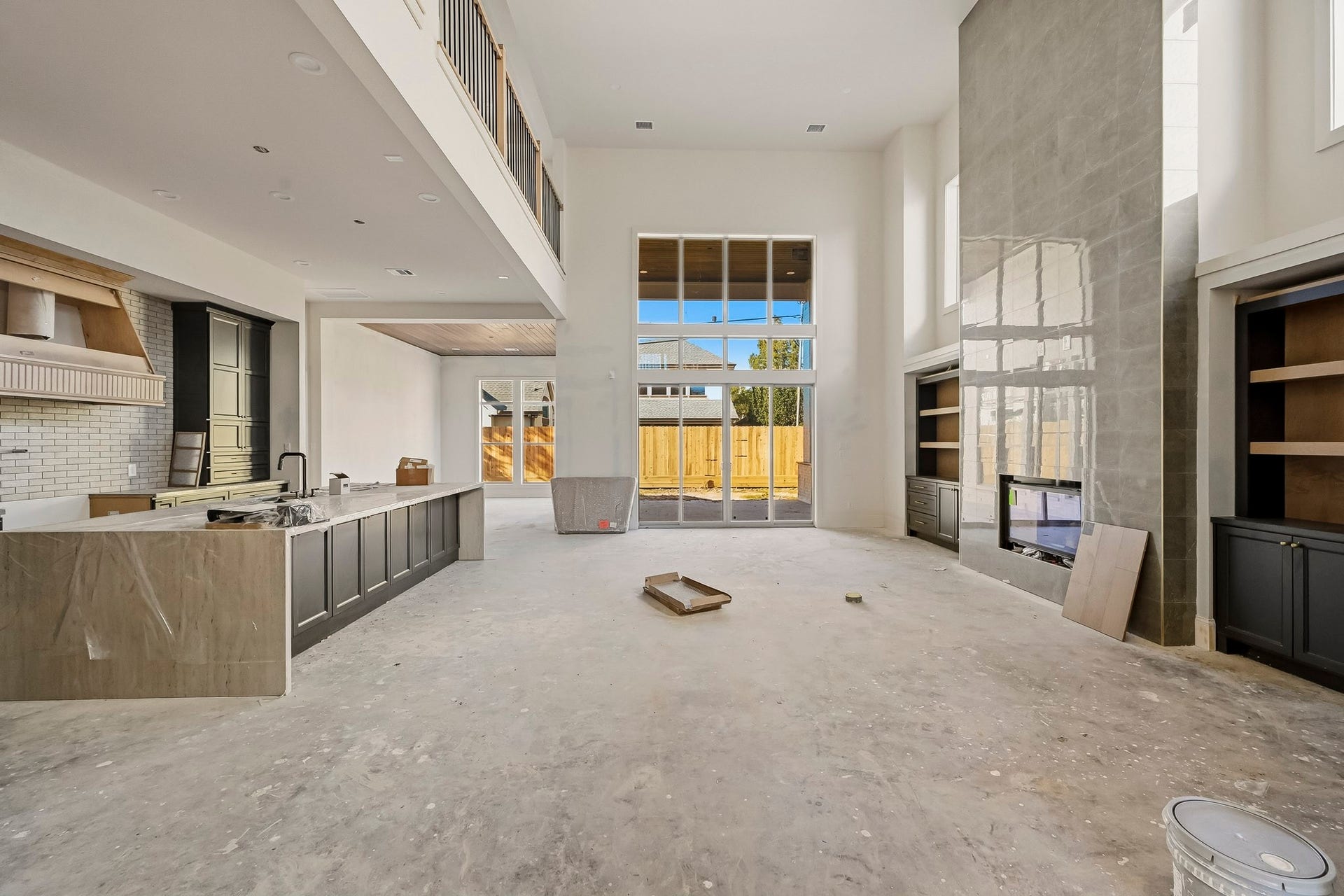 6618 Sivley Street, Hockley, TX 77055 Stunning two-story living area with expansive windows, a sleek fireplace, and a modern open-plan kitchen, perfect for entertaining and relaxation!