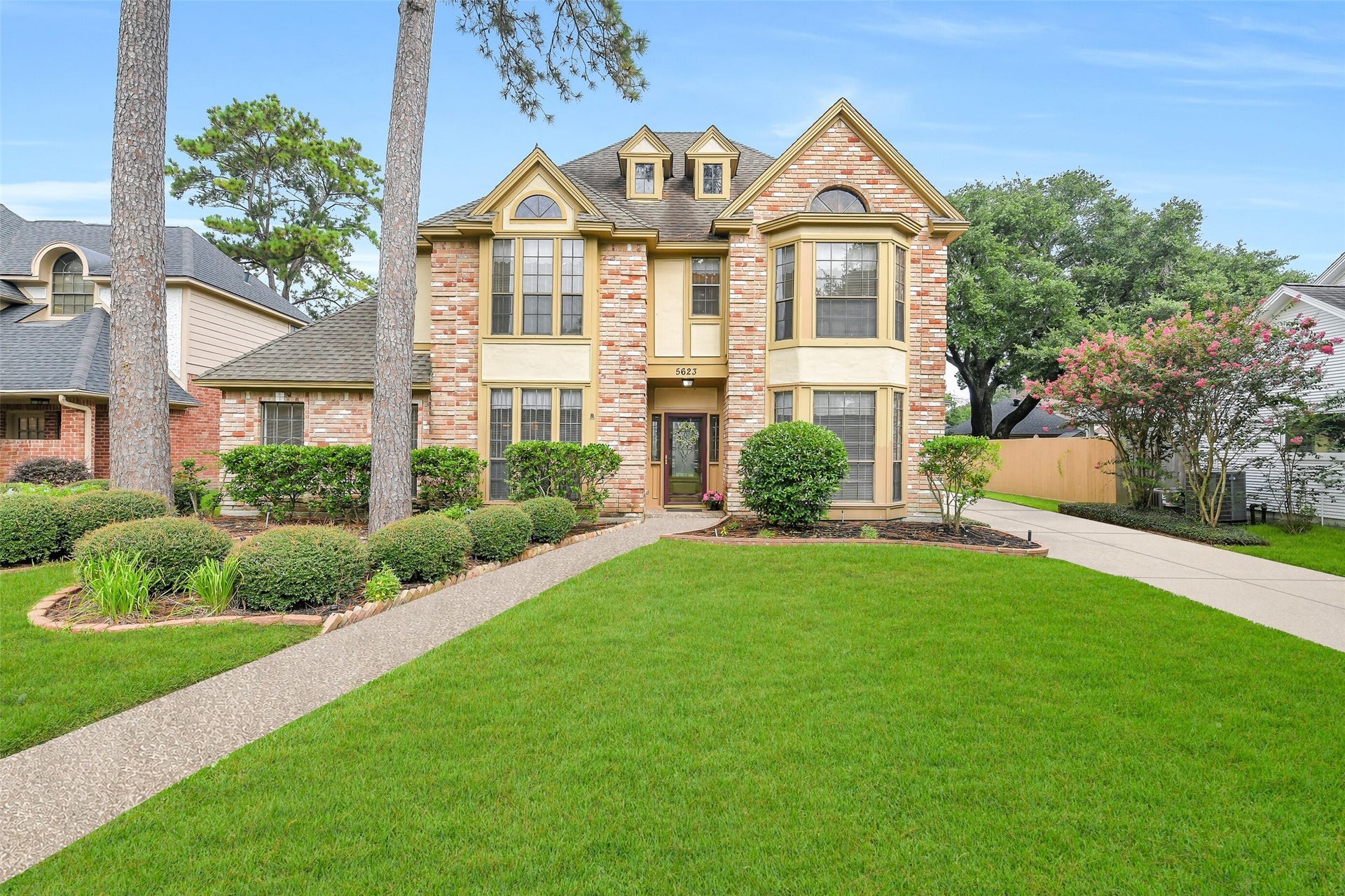 5623 Spring Lodge Drive, Kingwood, TX 77345 Beautiful curb appeal surrounded by mature trees and established landscaping in Sand Creek Village.