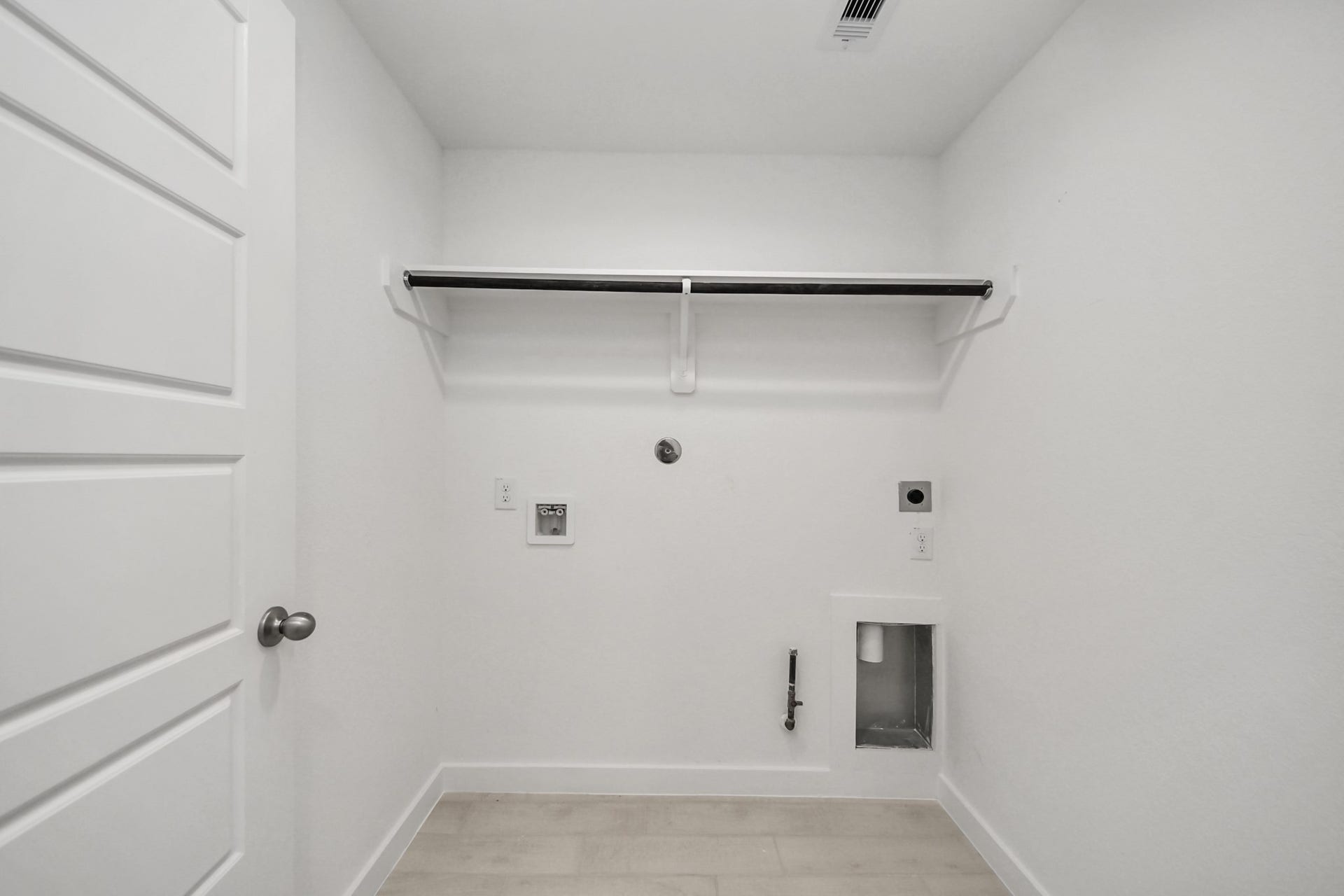 A perfect blend of functionality and comfort. Capture the essence of easy living with a first-floor laundry room, thoughtfully equipped with shelving for effortless organization. Both electric and gas connections available. Sample photo of completed home with similar floor plan. Actual colors and selections may vary.