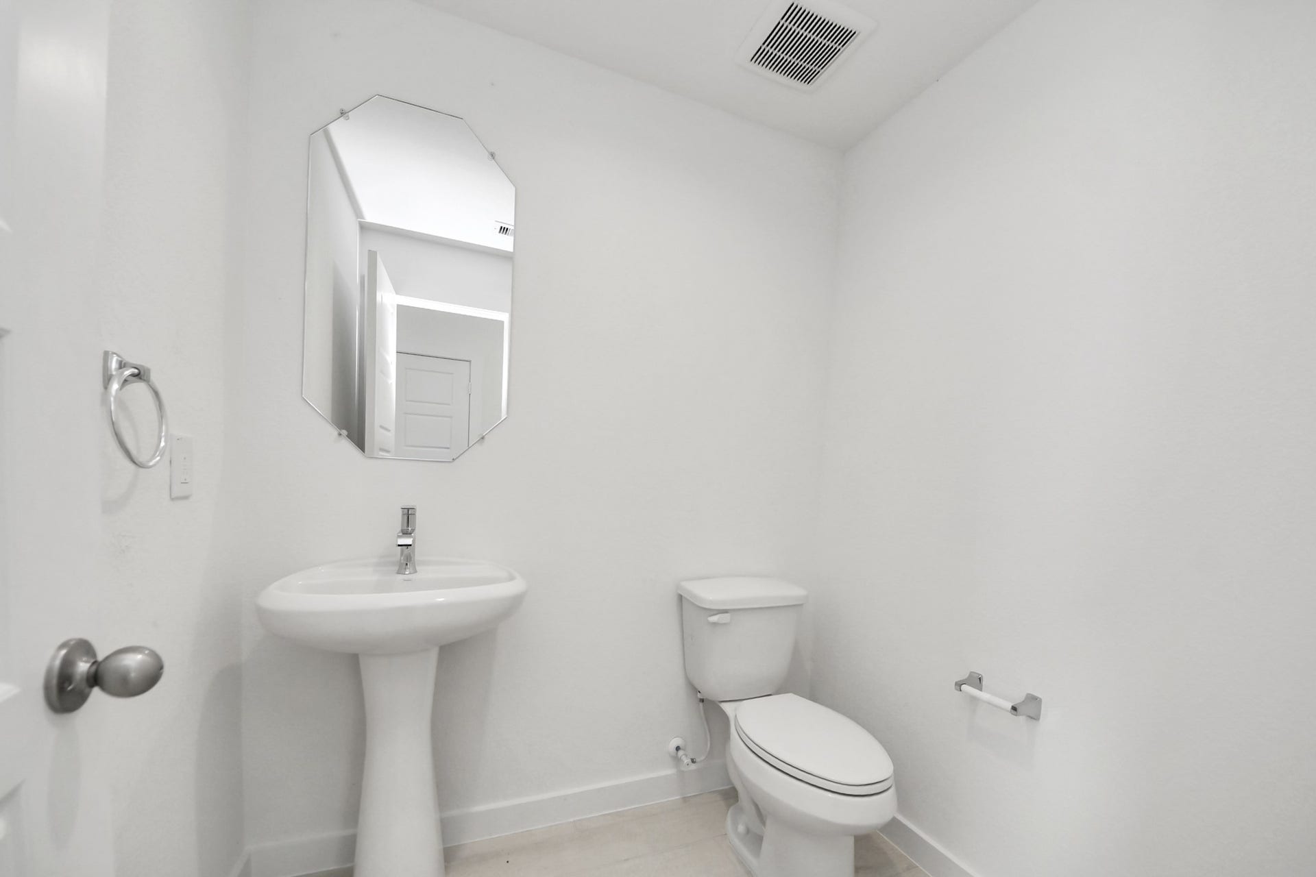 This half bathroom features a stylish pedestal sink, modern hardware, and bright recessed lighting, creating a sleek and inviting space. Sample photo of completed home with similar floor plan. Actual colors and selections may vary.