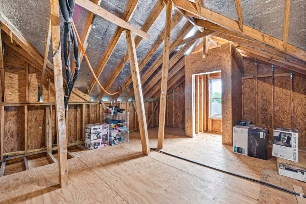 10114 Brush Way, Rosharon, TX 77583 Spacious flex attic with exposed beams and ample natural light, offering potential for customization or storage.