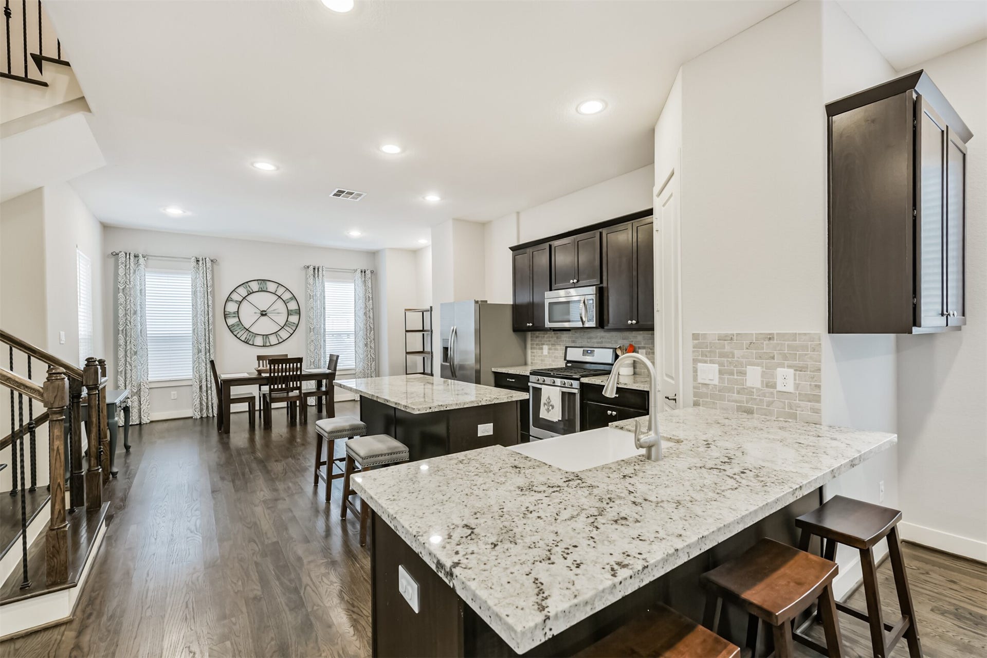 Highlighting the expansive kitchen on the second floor with gleaming light-colored granite countertops, solid hardwood floors, and light grey walls- this home is both modern and homey!