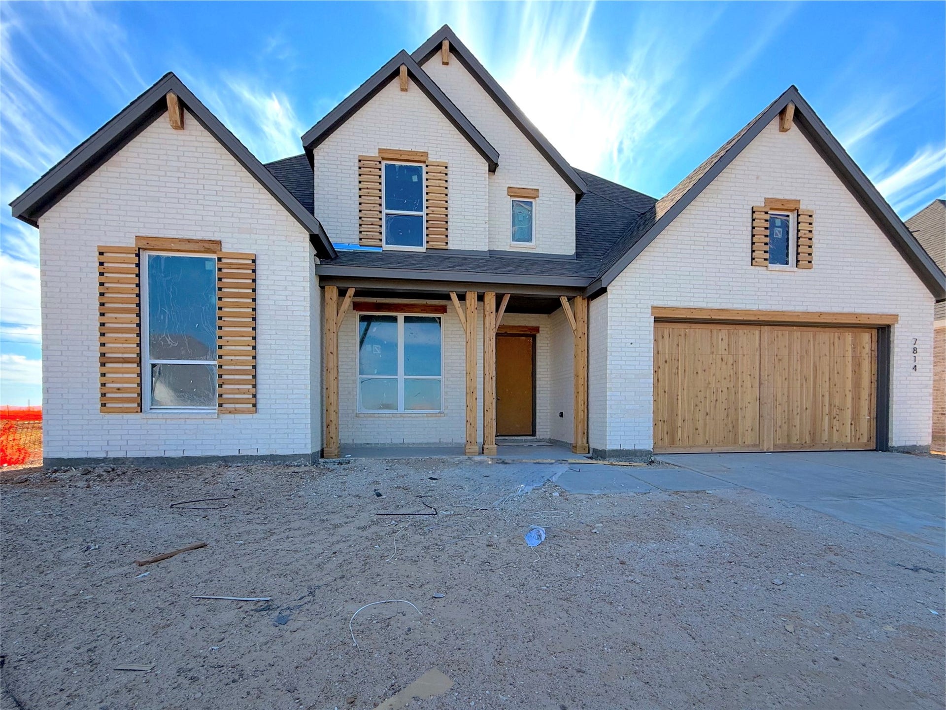 Classic ivory brick elevation with charming architectural details and a welcoming front porch