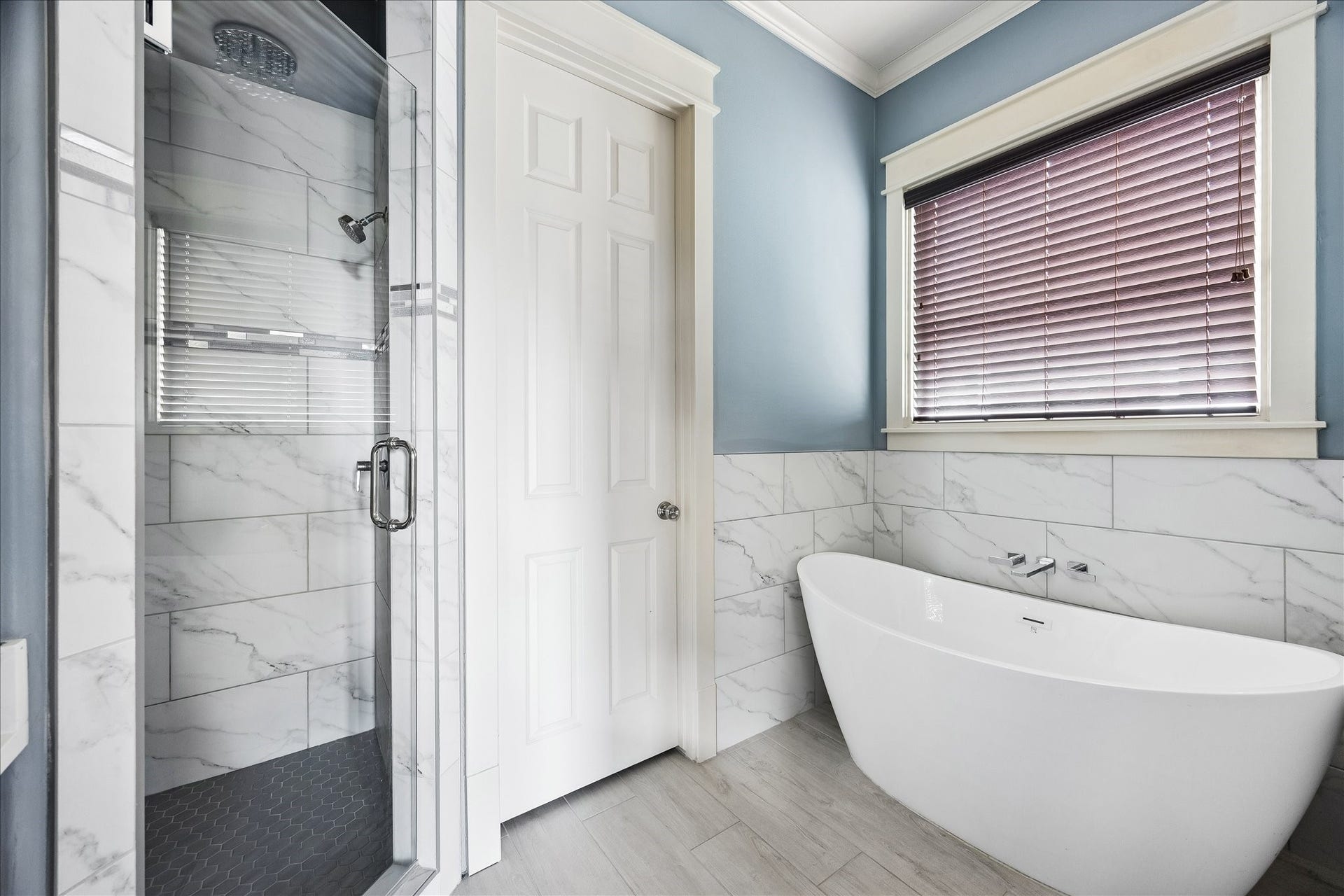 1332 W 21st Street, #B, Houston, TX 77008 Tile surrounds a freestanding soaking tub and separate glass-enclosed shower, creating a beautifully cohesive design.