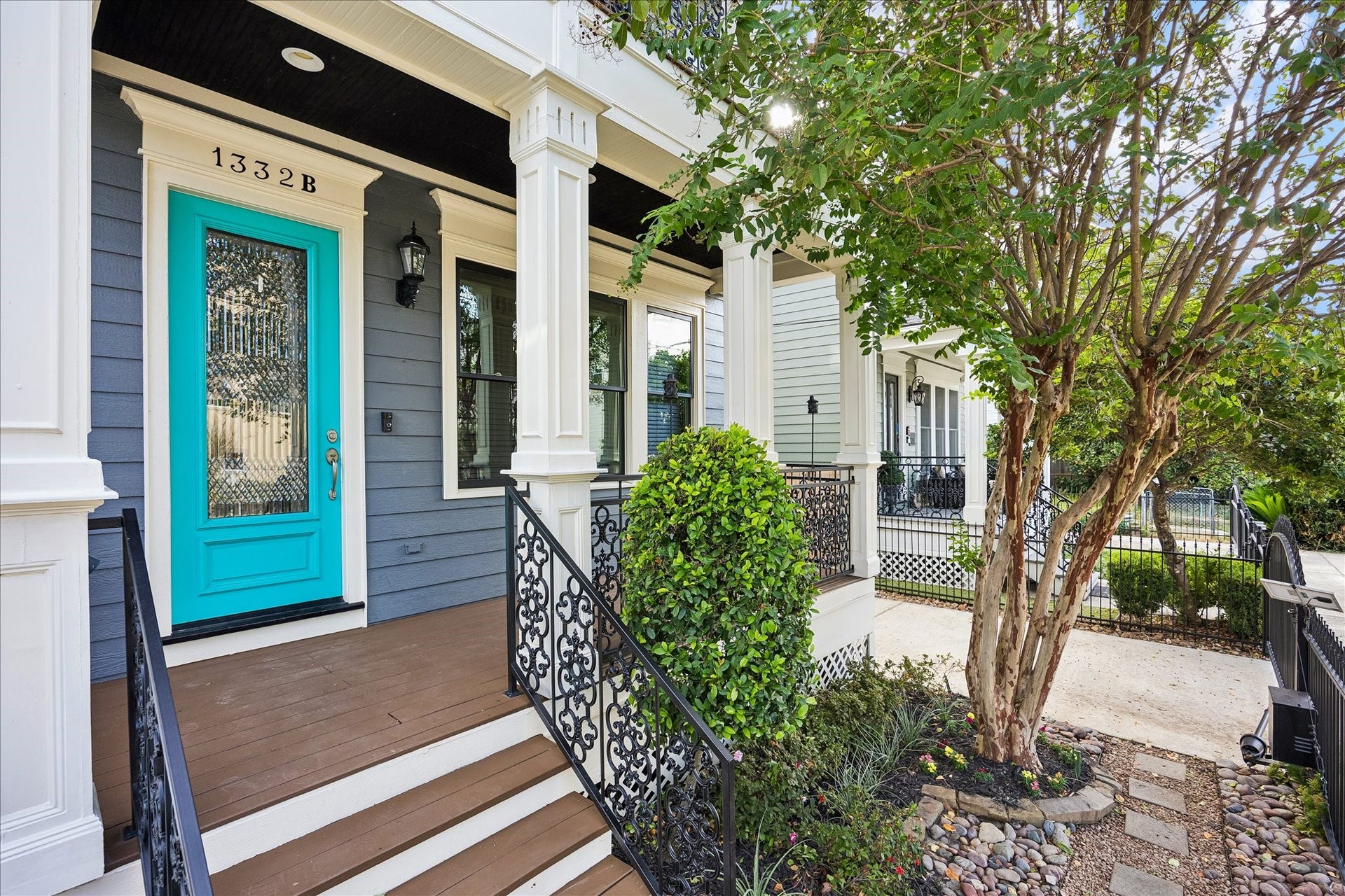 1332 W 21st Street, #B, Houston, TX 77008 A vibrant turquoise entry door adds a playful touch to the classic columns, intricate iron railings, and welcoming front porch.