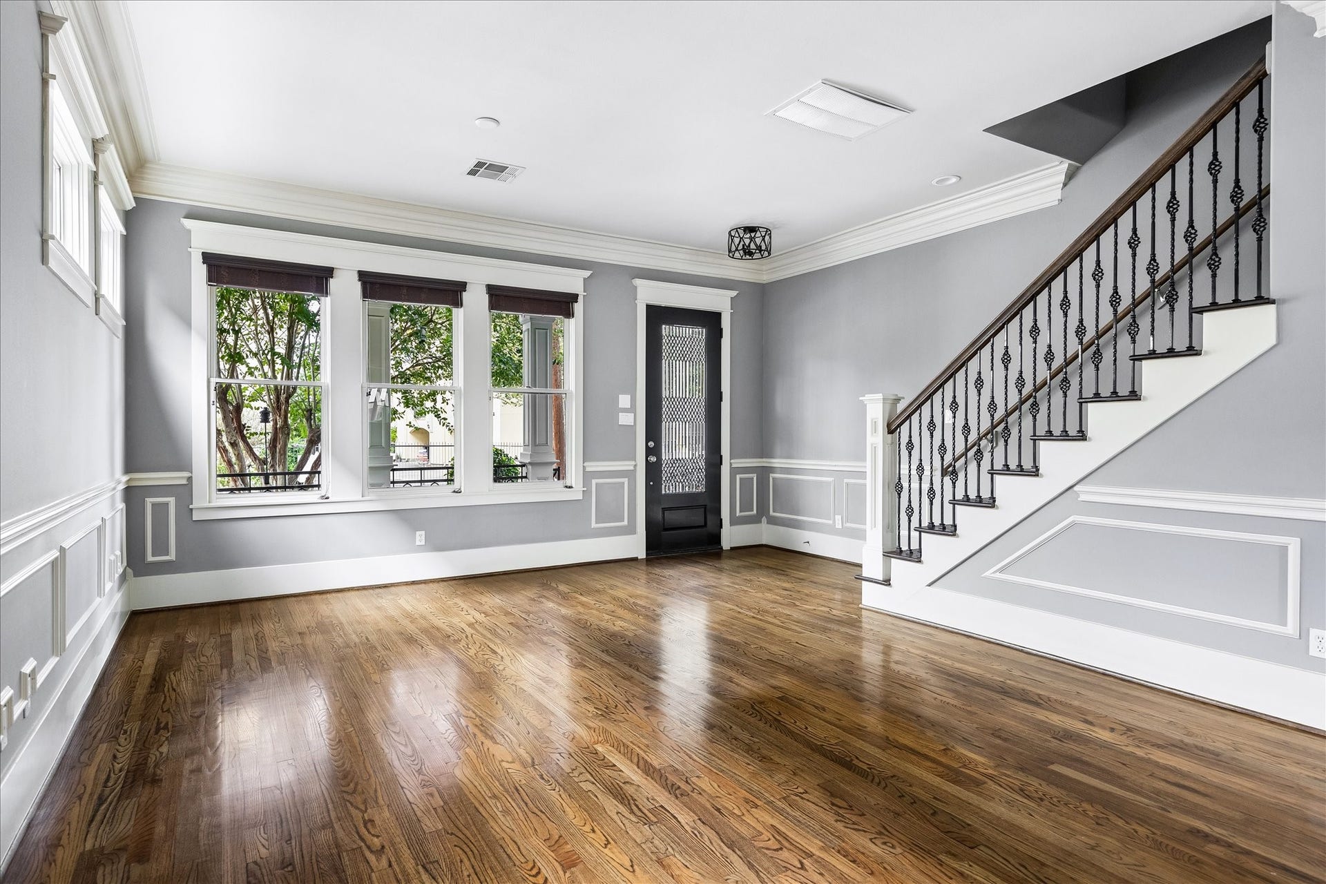 1332 W 21st Street, #B, Houston, TX 77008 A welcoming view of the front living room highlights the graceful staircase, intricate ironwork, and beautifully detailed millwork throughout.