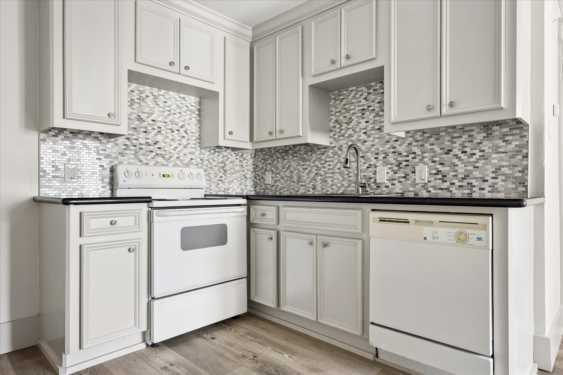1332 W 21st Street, #B, Houston, TX 77008 A well-equipped kitchenette features raised-panel cabinetry, mosaic tile backsplash, and full-size appliances.