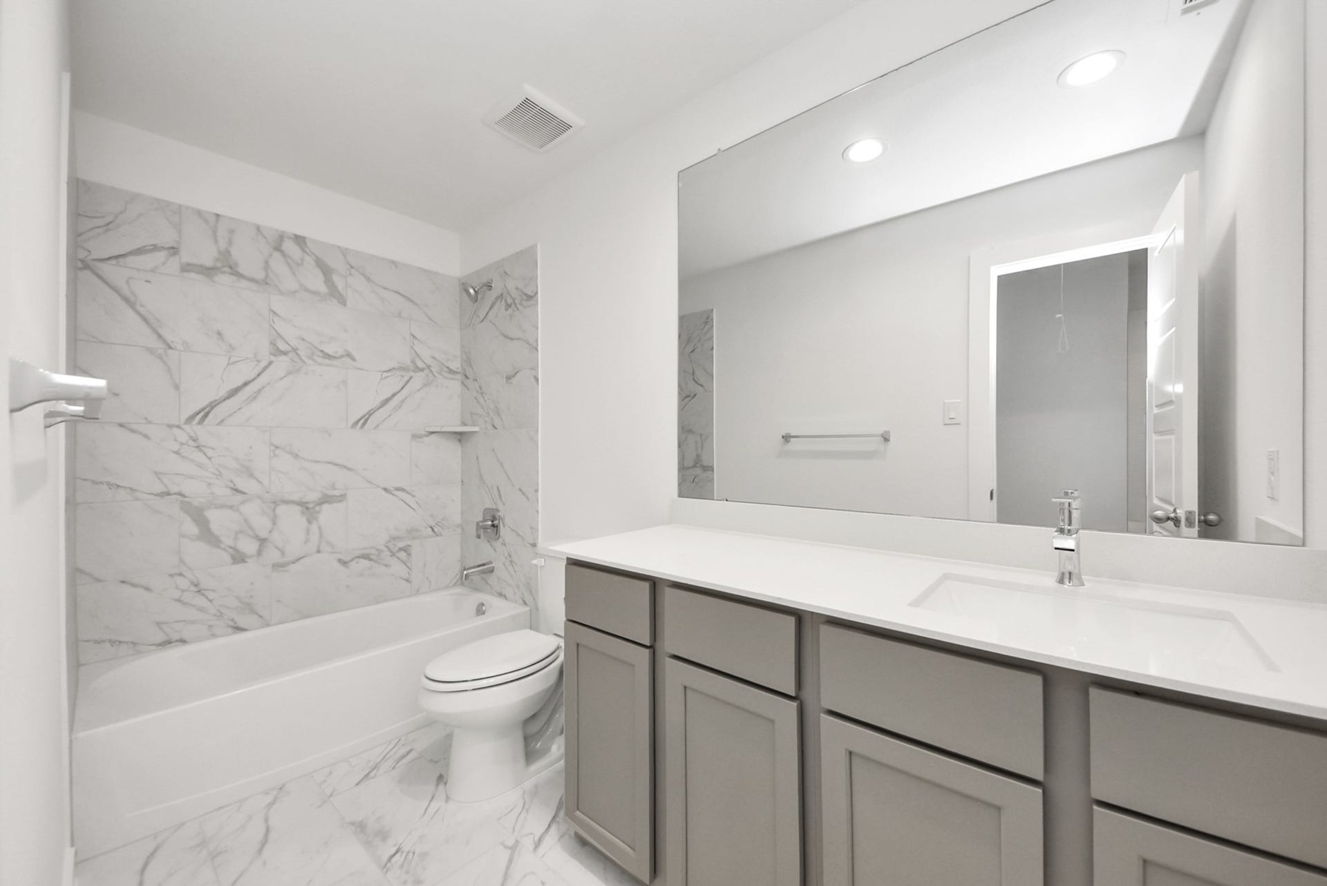 11119 Rose River Drive, Houston, TX 77044 Secondary bath features tile flooring, bath/shower combo with tile surround, light stained wood cabinets, beautiful light countertop.