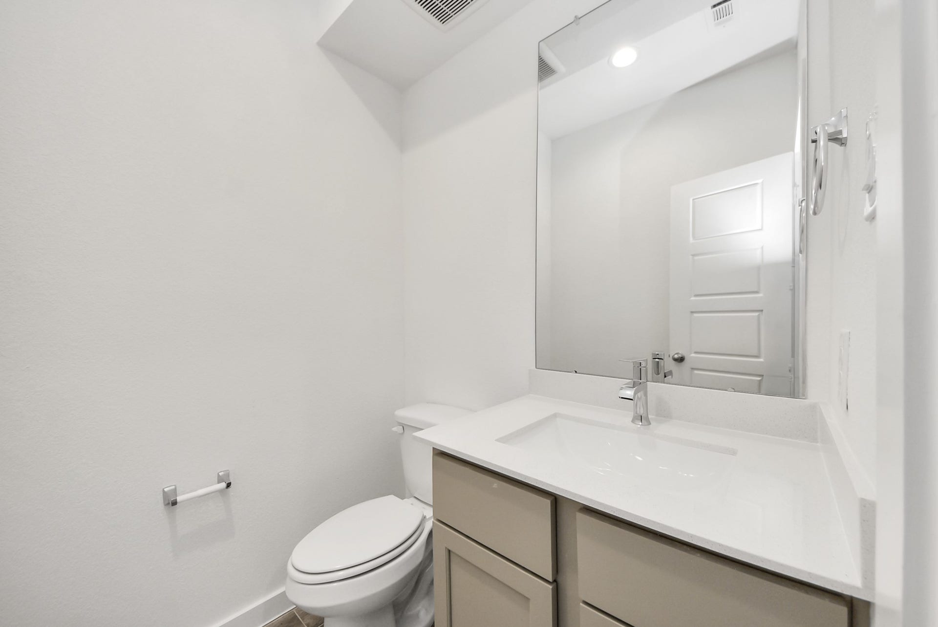 11119 Rose River Drive, Houston, TX 77044 Sophisticated half bathroom adorned with contemporary finishes. The elegant 5-panel door welcomes you to a space where style meets functionality. Notice the sleek hardware accents that add a touch of modern charm. The vanity boasts light-colored countertops, beautifully complemented by a tasteful vanity light, creating a well-lit and inviting atmosphere.
