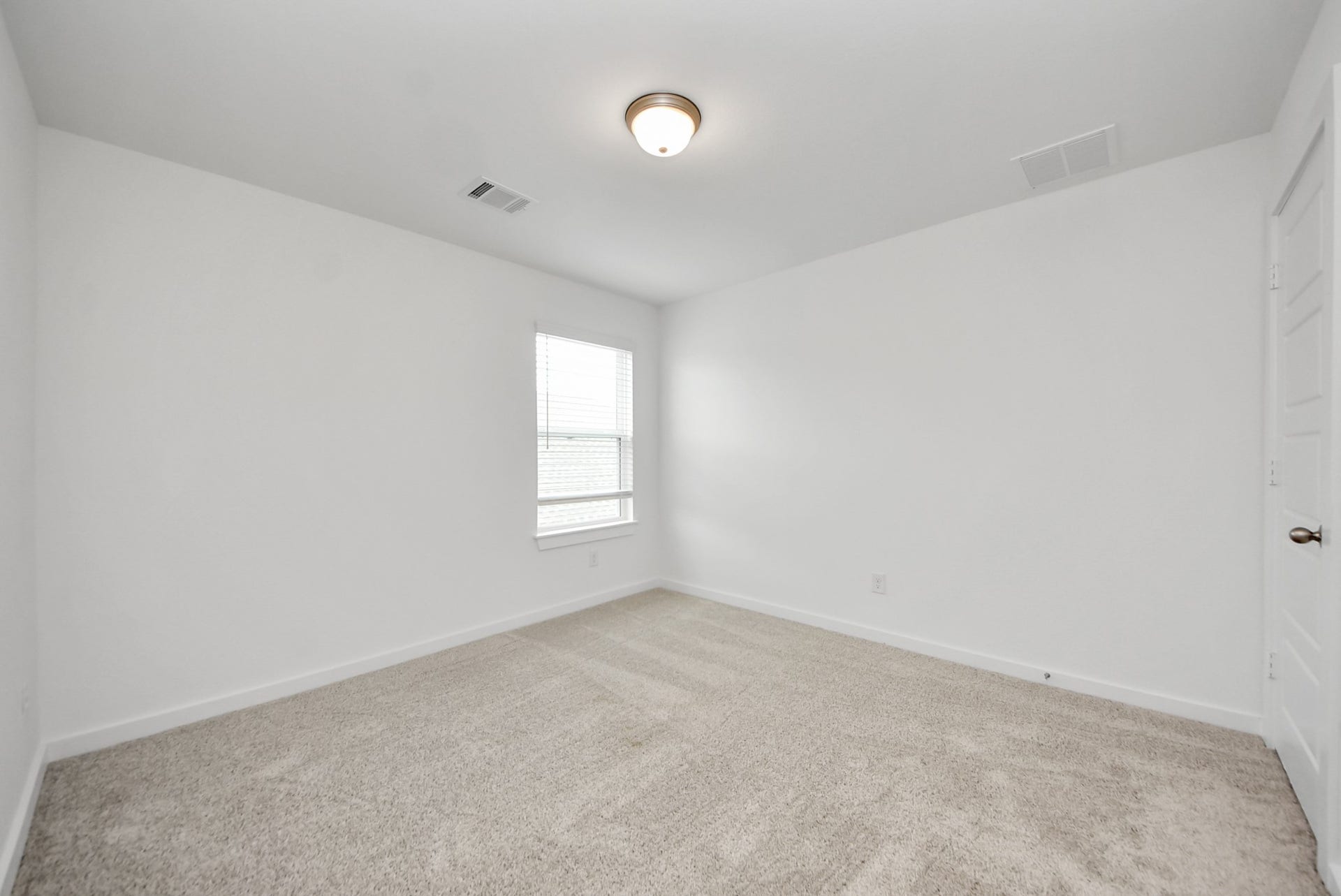 11119 Rose River Drive, Houston, TX 77044 Secondary bedroom features plush carpeting, large windows that let in plenty of natural light, bright paint, and spacious closets.