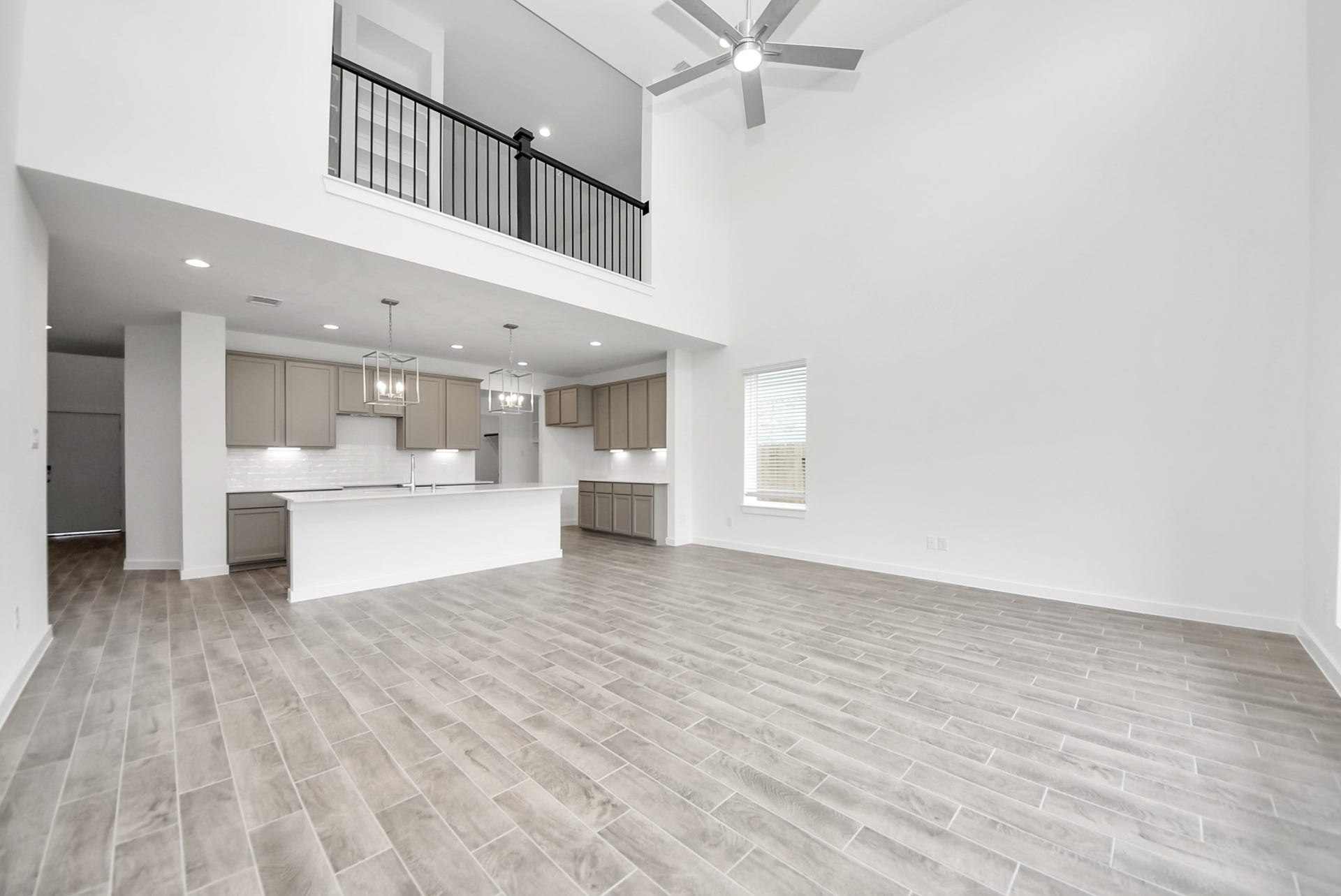 11119 Rose River Drive, Houston, TX 77044 Relax and unwind in this inviting family room, illuminated by abundant natural light streaming in through tall windows, complemented by high ceilings and stunning flooring. Stay comfortable year-round with the gentle breeze from the ceiling fan, creating the perfect atmosphere for family gatherings.