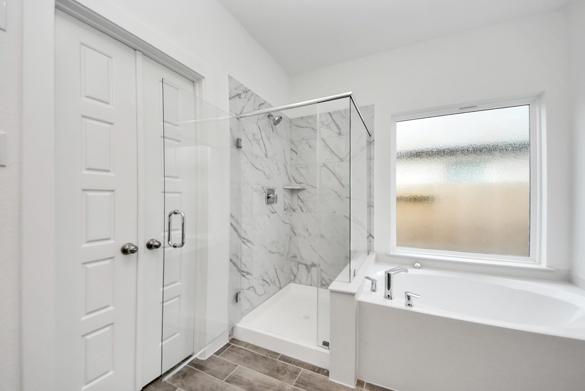 11119 Rose River Drive, Houston, TX 77044 Indulge in a spa-like retreat within the confines of this primary bathroom. Delight in a spacious walk-in shower enveloped in stylish tile surround, unwind in a separate garden tub adorned with custom detailing.